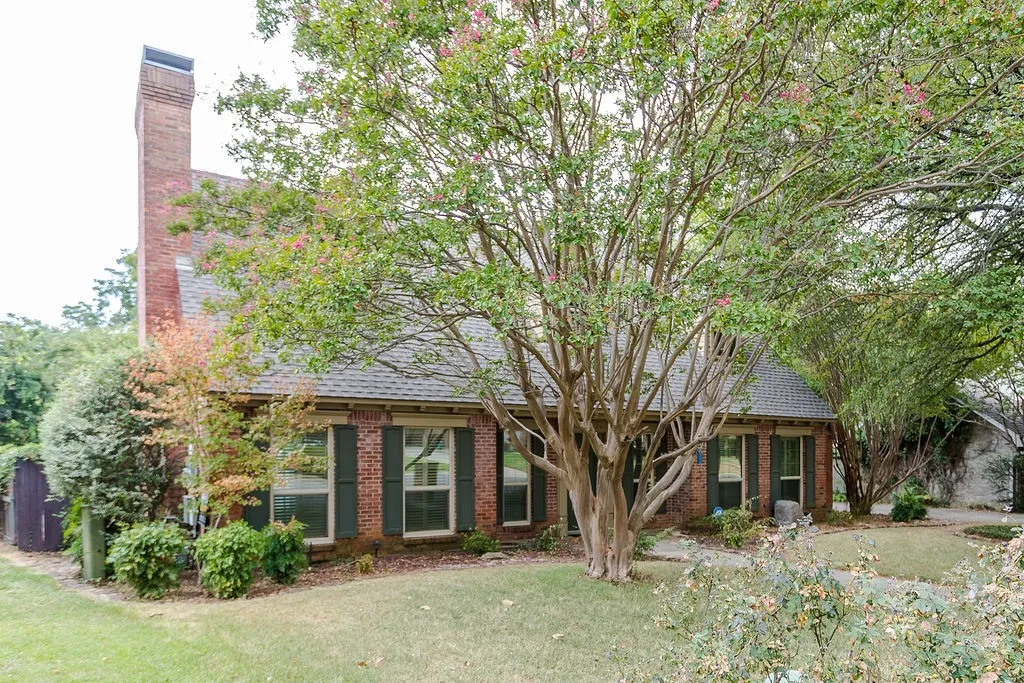 Brick exterior with a prominent chimney and dark-shutter windows