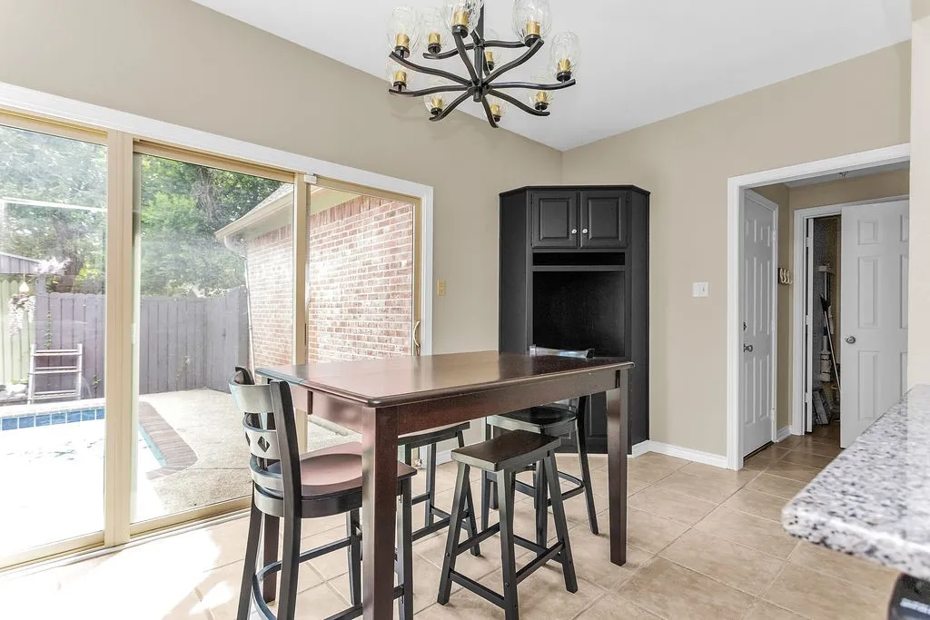 Tile flooring, corner cabinet with upper storage, and sliding glass door to outdoor area with pool