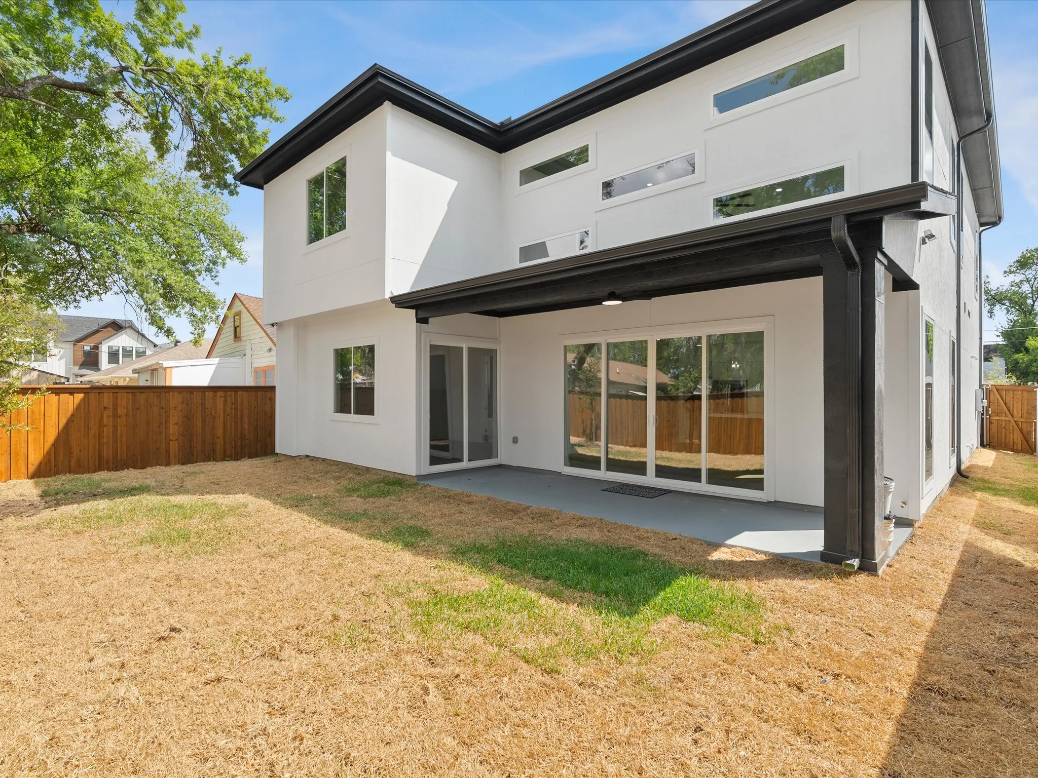 Modern white stucco, covered patio, and sliding doors to master bedroom and living area.