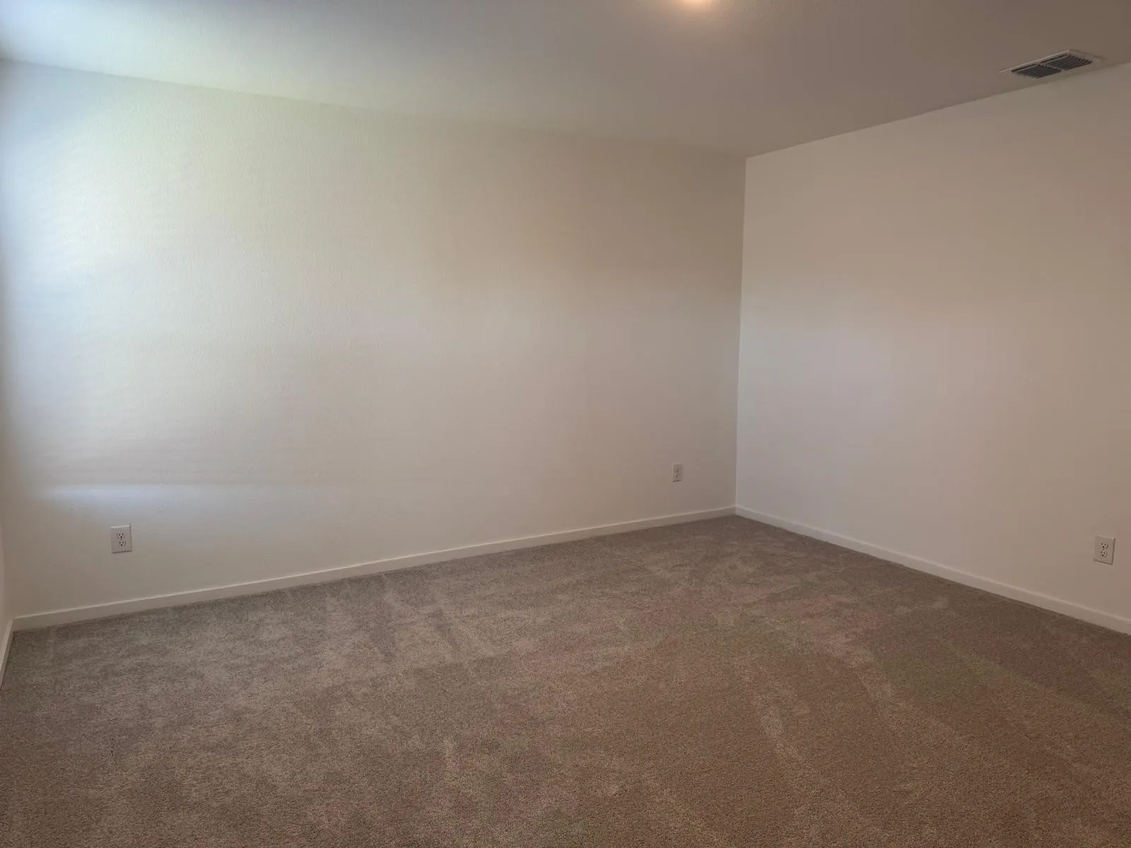 Carpeted empty room featuring baseboards