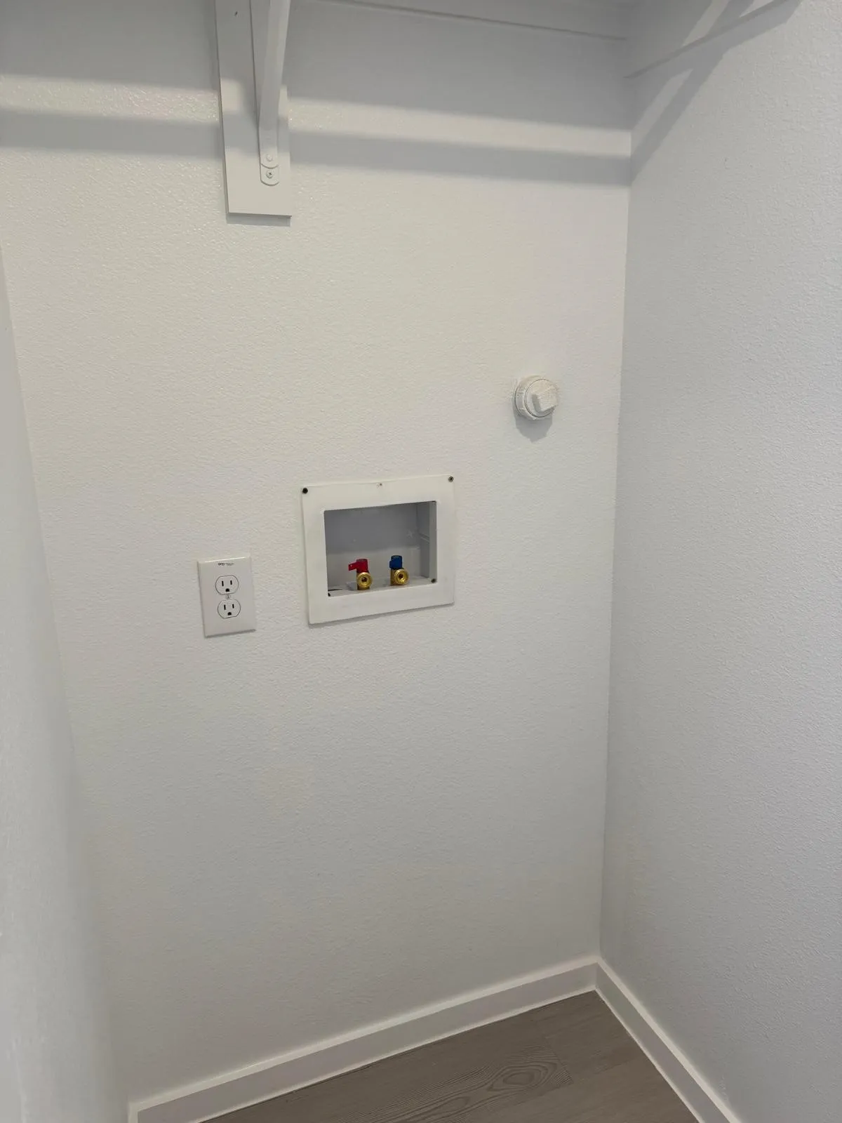 Laundry room with dark wood-style flooring, hookup for a washing machine, and a textured wall
