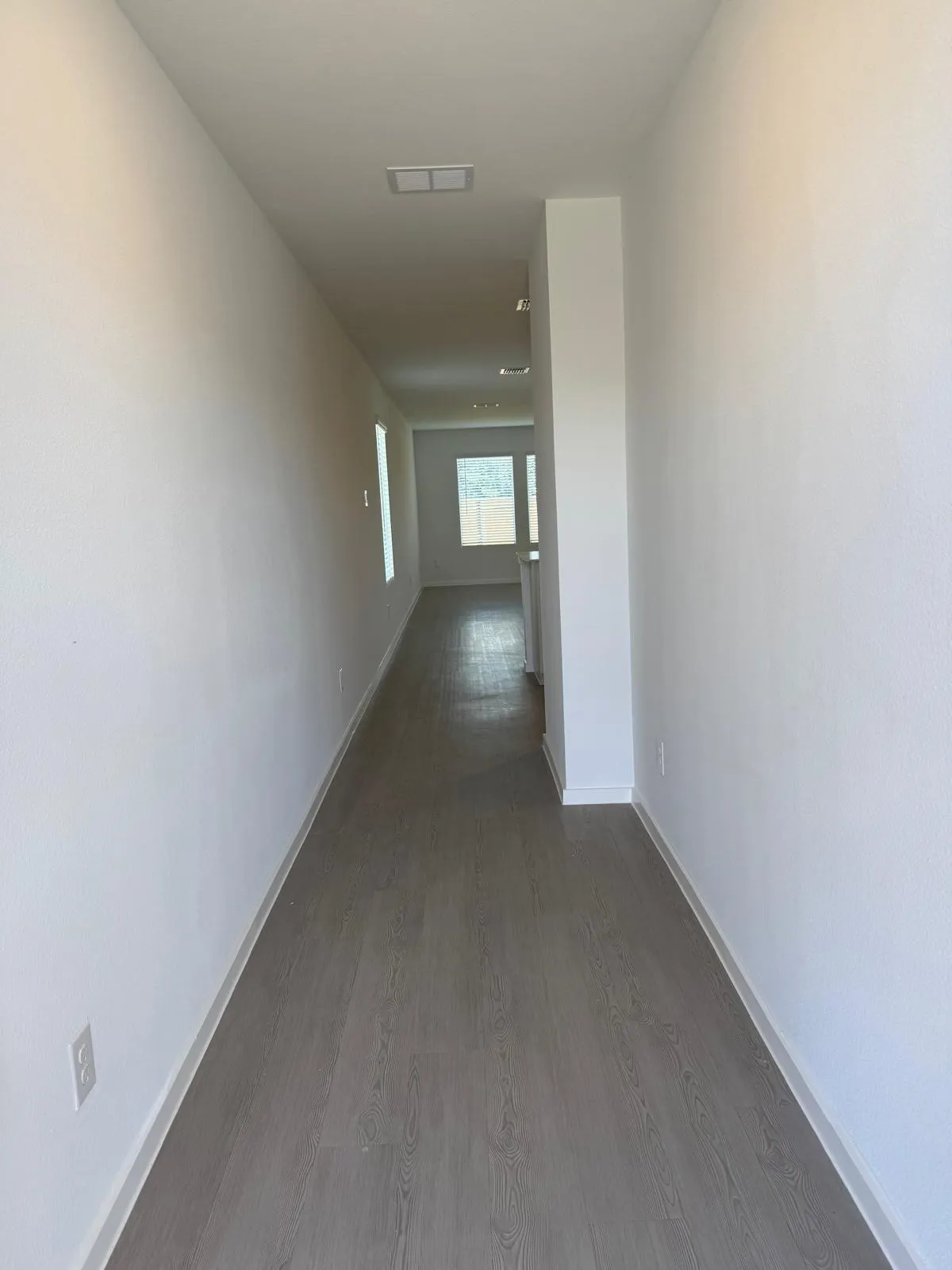 Hallway featuring dark wood-type flooring and baseboards