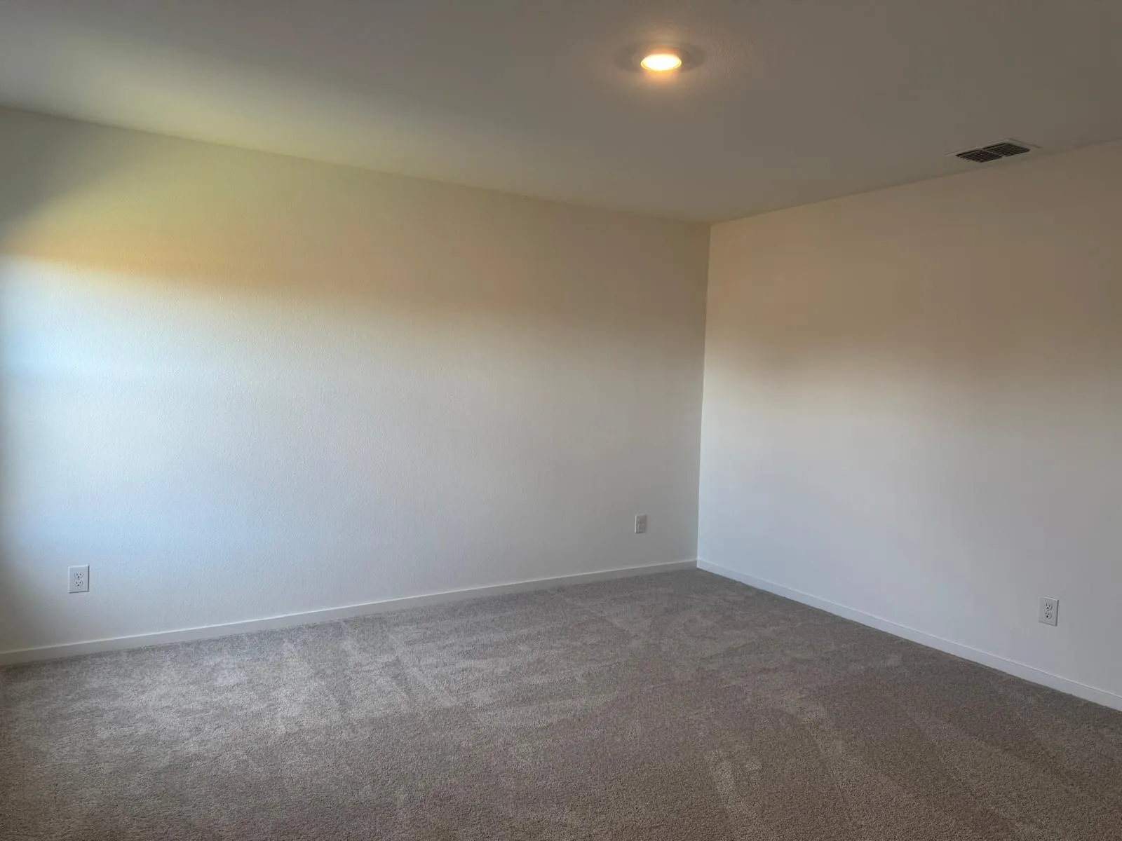 Carpeted empty room with baseboards