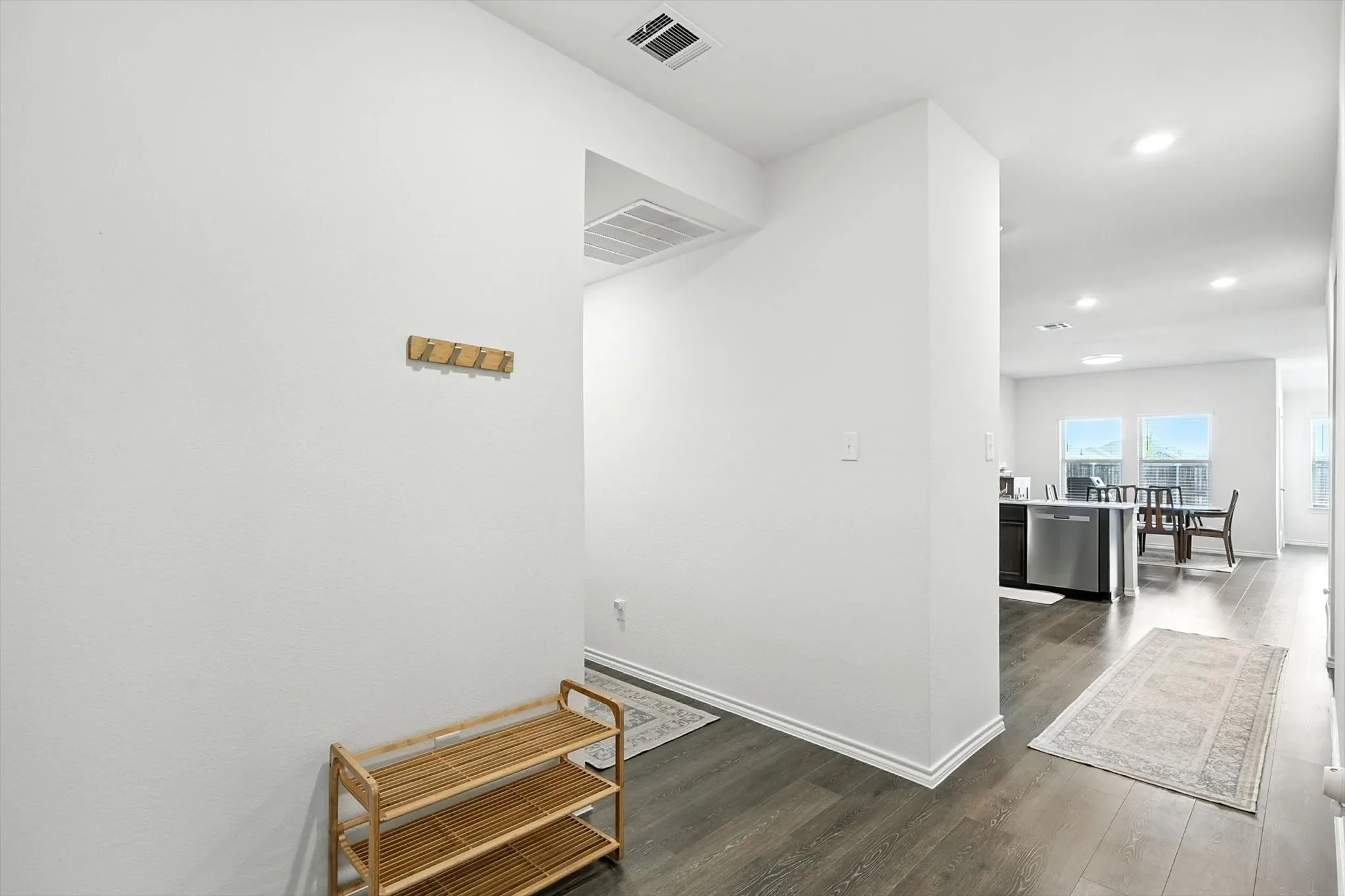 Hallway entry with wood-finish flooring, recessed lighting, and a neutral wall palette