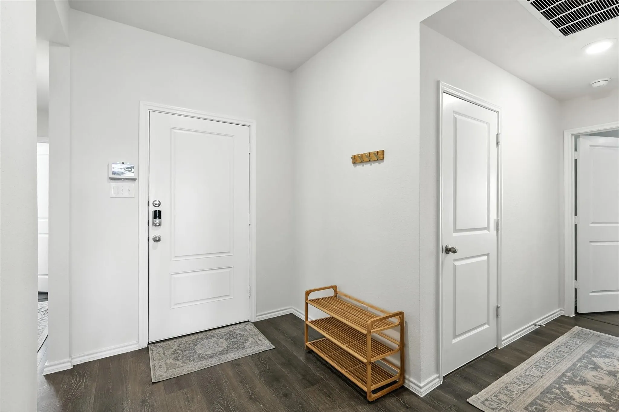 Wood-finish flooring, white paneled doors, and recessed ceiling lighting