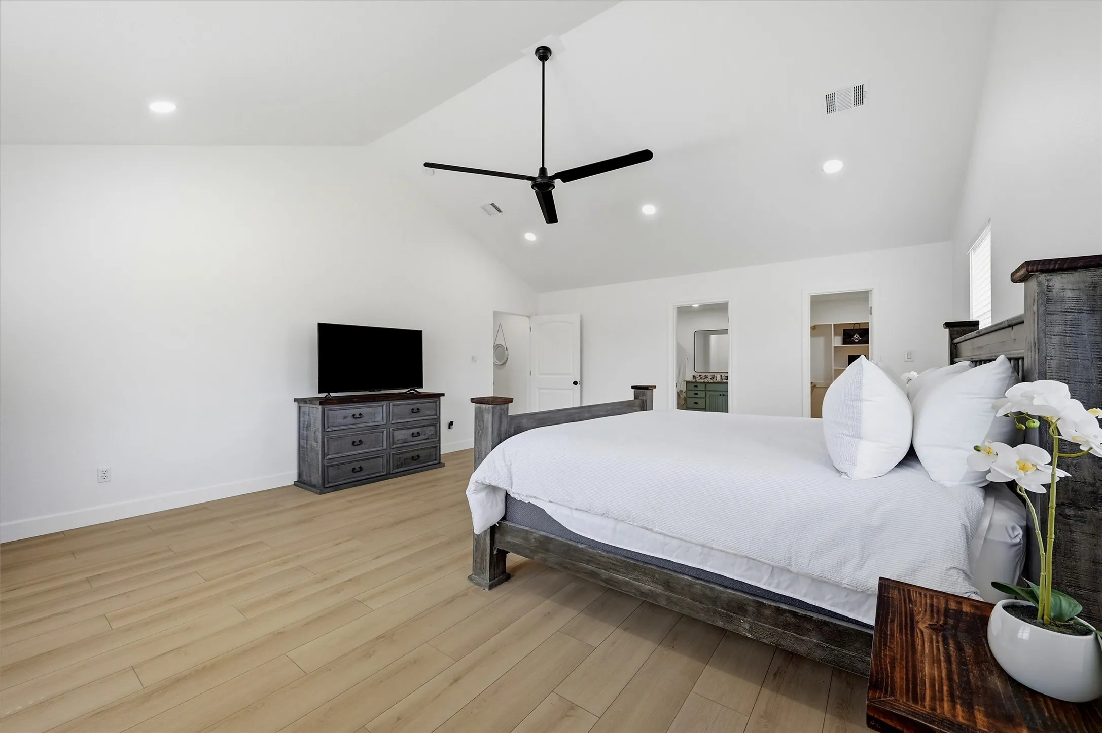 Vaulted ceiling with a ceiling fan, recessed lighting, and wood-finish flooring