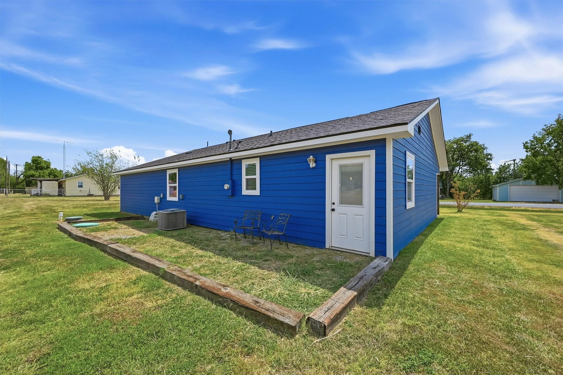 Blue siding exterior with white trim and a dark shingle roof