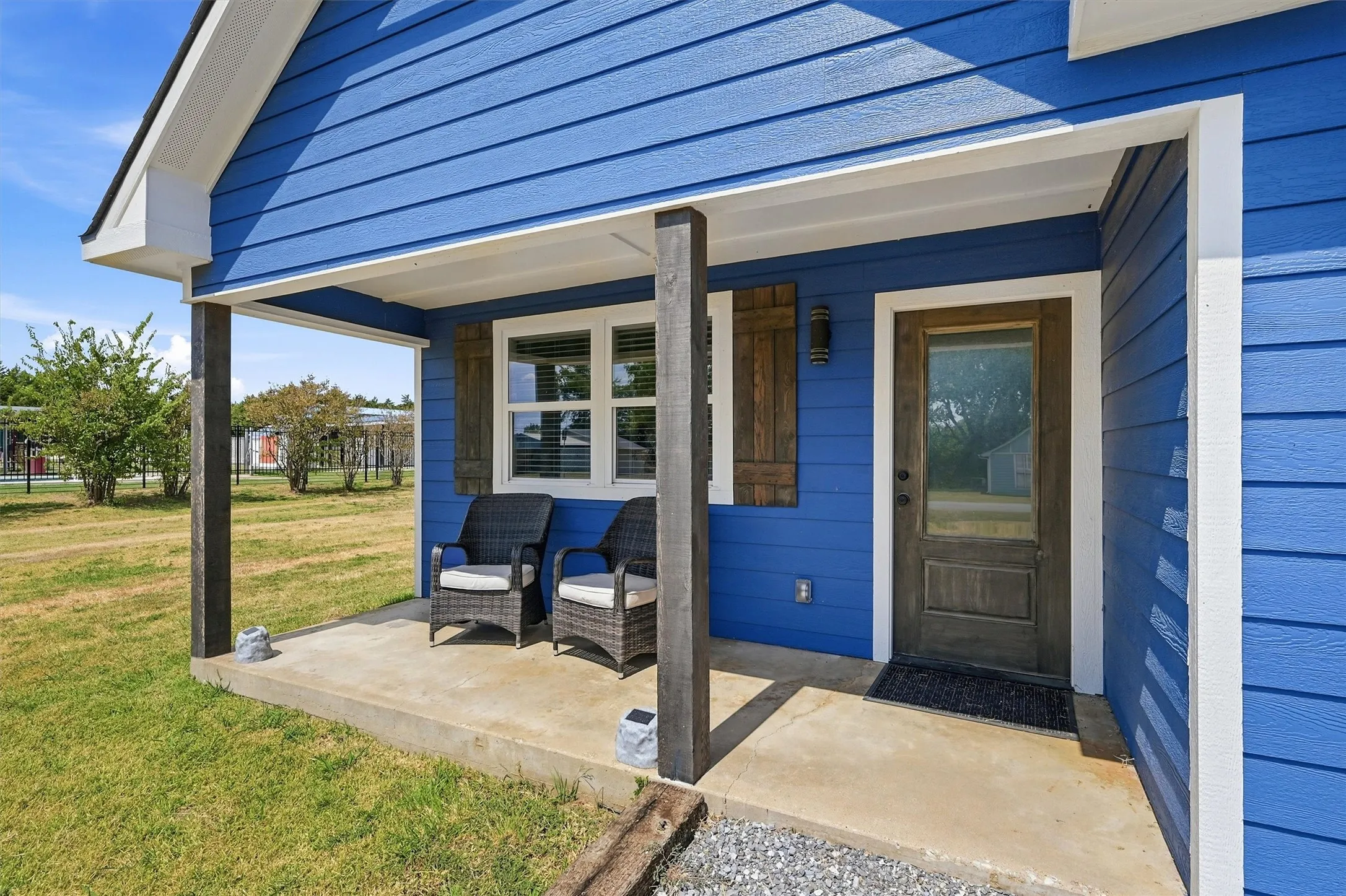 Covered front porch with concrete flooring and wood support beams