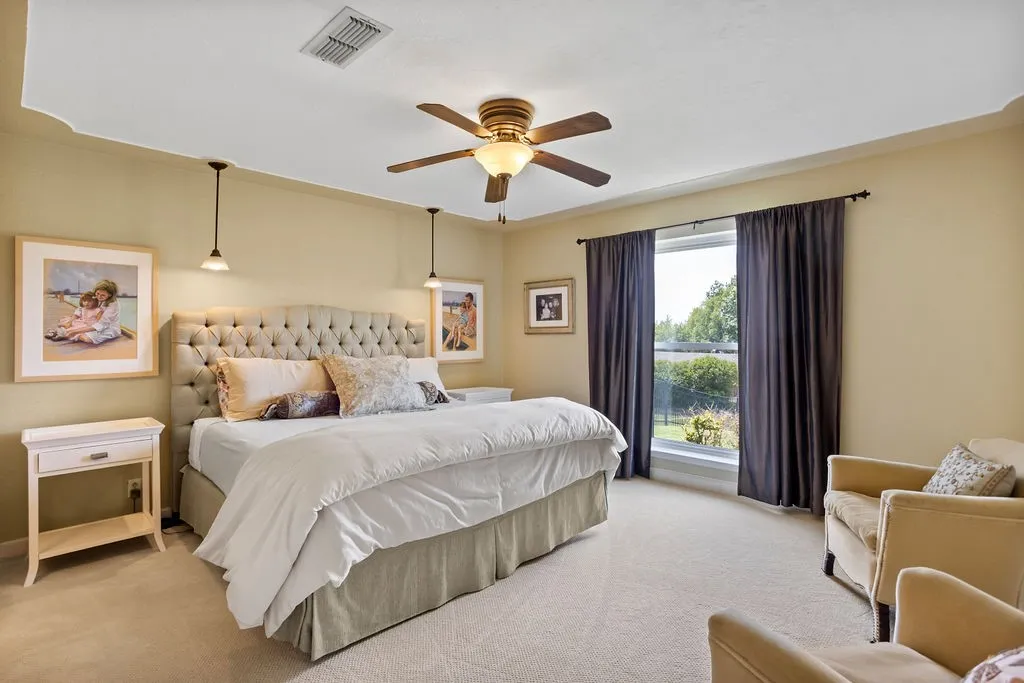 Spacious primary bedroom with lake view and recessed ceiling