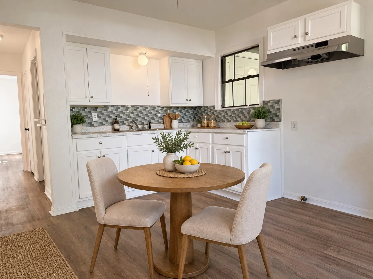 White cabinetry with stainless steel hardware, mosaic tile backsplash, solid surface countertops, a stainless steel range hood, and wood-finish flooring