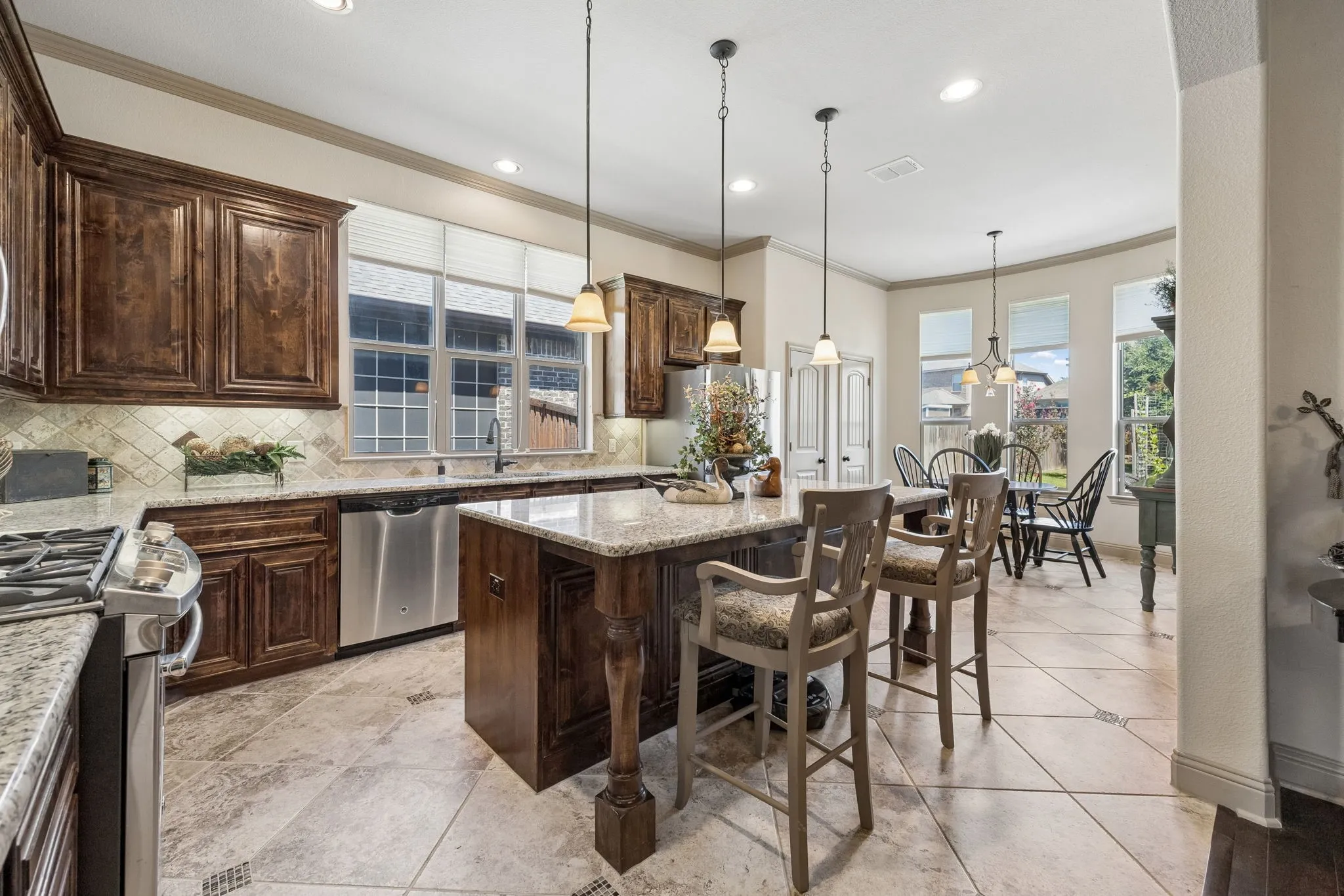 Kitchen featuring wood cabinetry, granite countertops, stainless steel appliances, and tile flooring