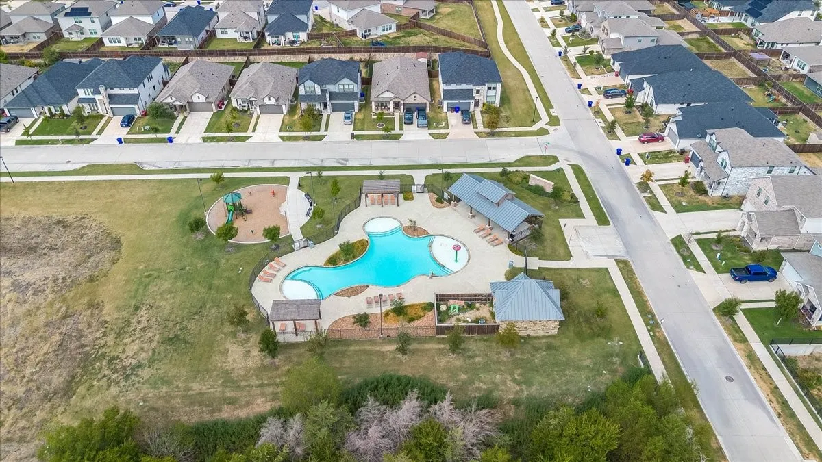Community pool with multiple lounge areas, adjacent playground, and covered outdoor structures