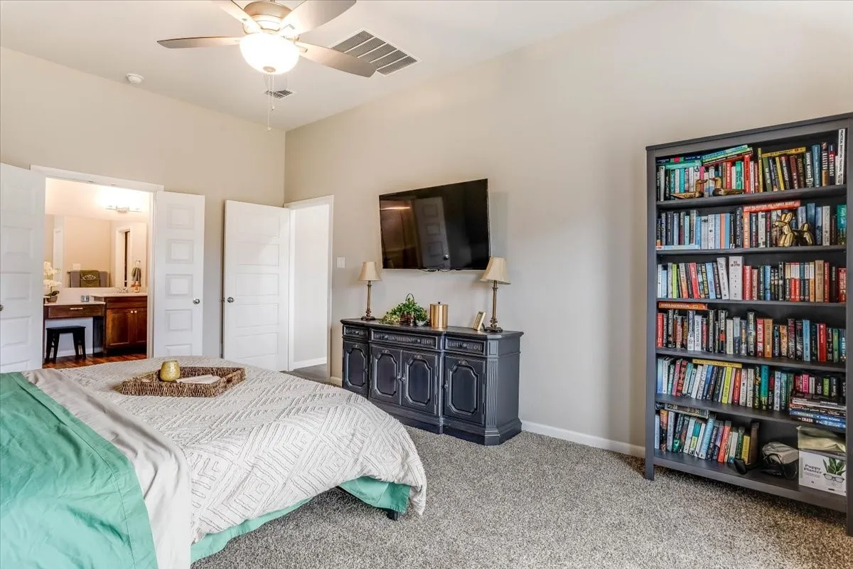 Recessed lighting and ceiling fan, built-in shelving, gray carpet, and wood-finish flooring in an adjoining room