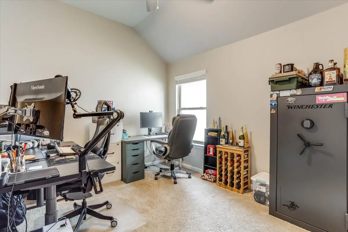 Vaulted ceiling with an overhead fan, carpeted flooring, and a window with blinds