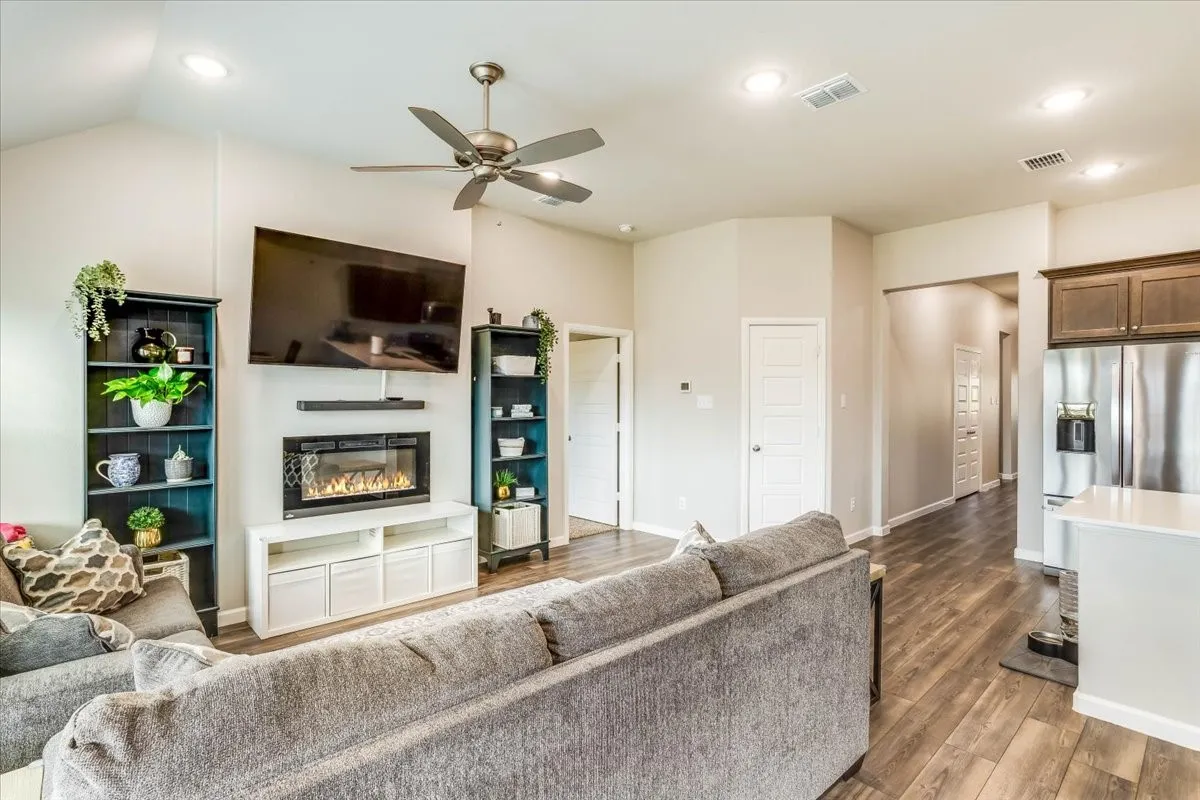 Vaulted ceiling, ceiling fan, wood-finish flooring, built-in electric fireplace, recessed lighting