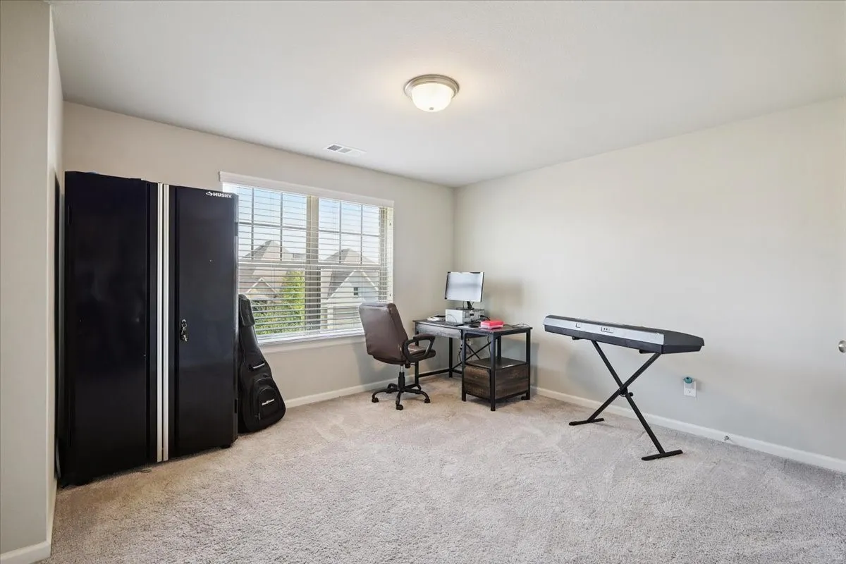 Bedroom with light colored carpet.
