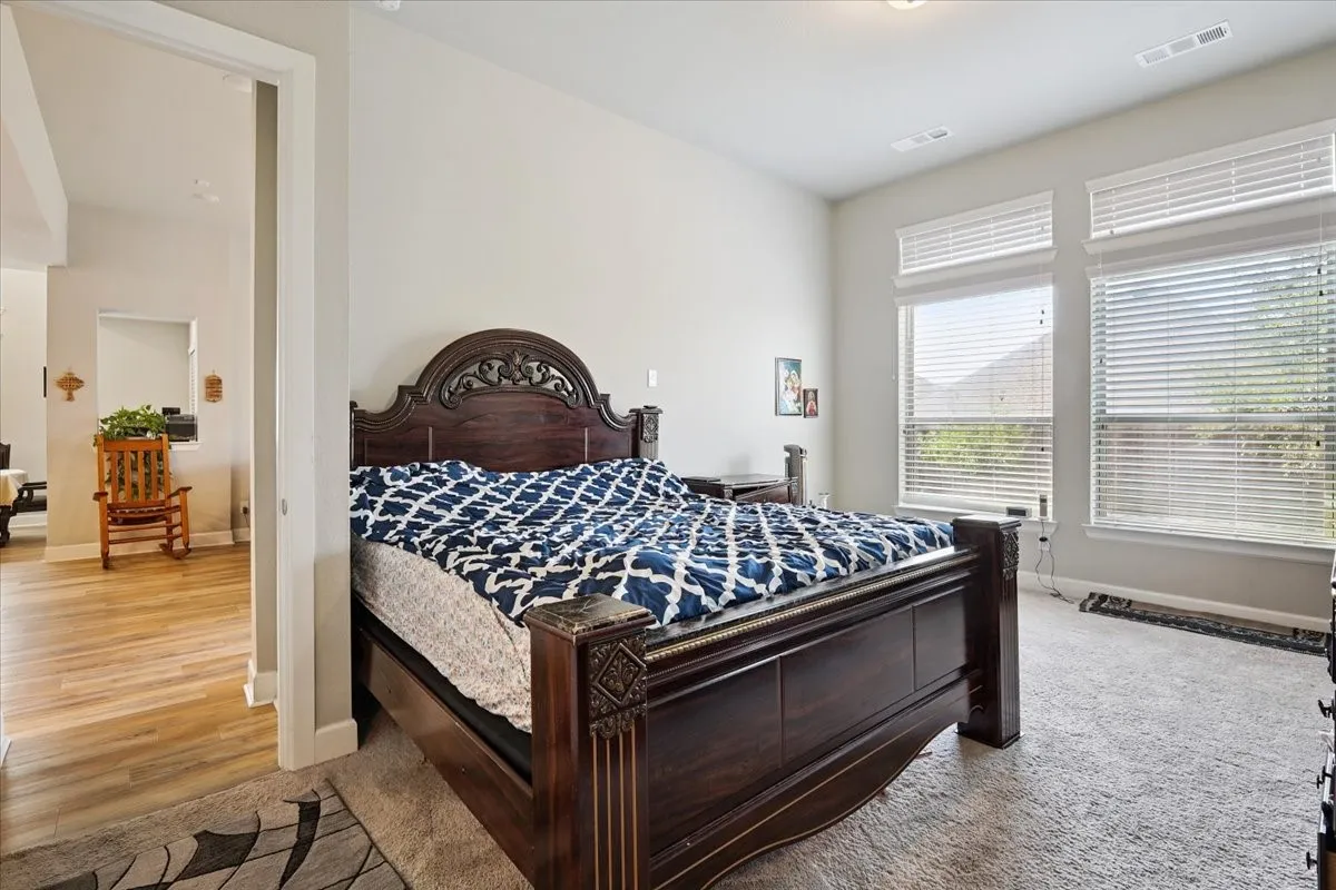 Bedroom with baseboards and light carpet