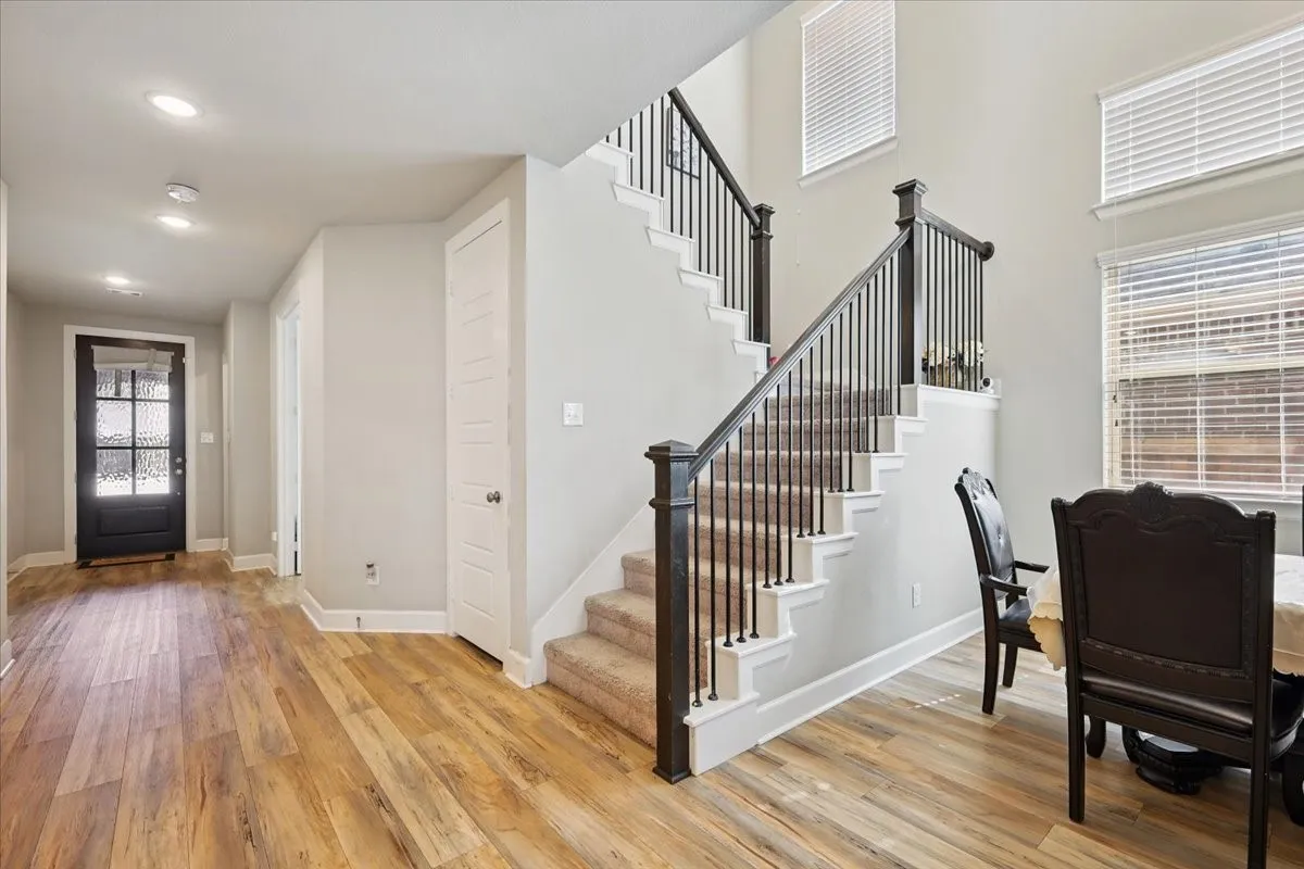 Foyer with light wood-type flooring, stairs, and a high ceiling