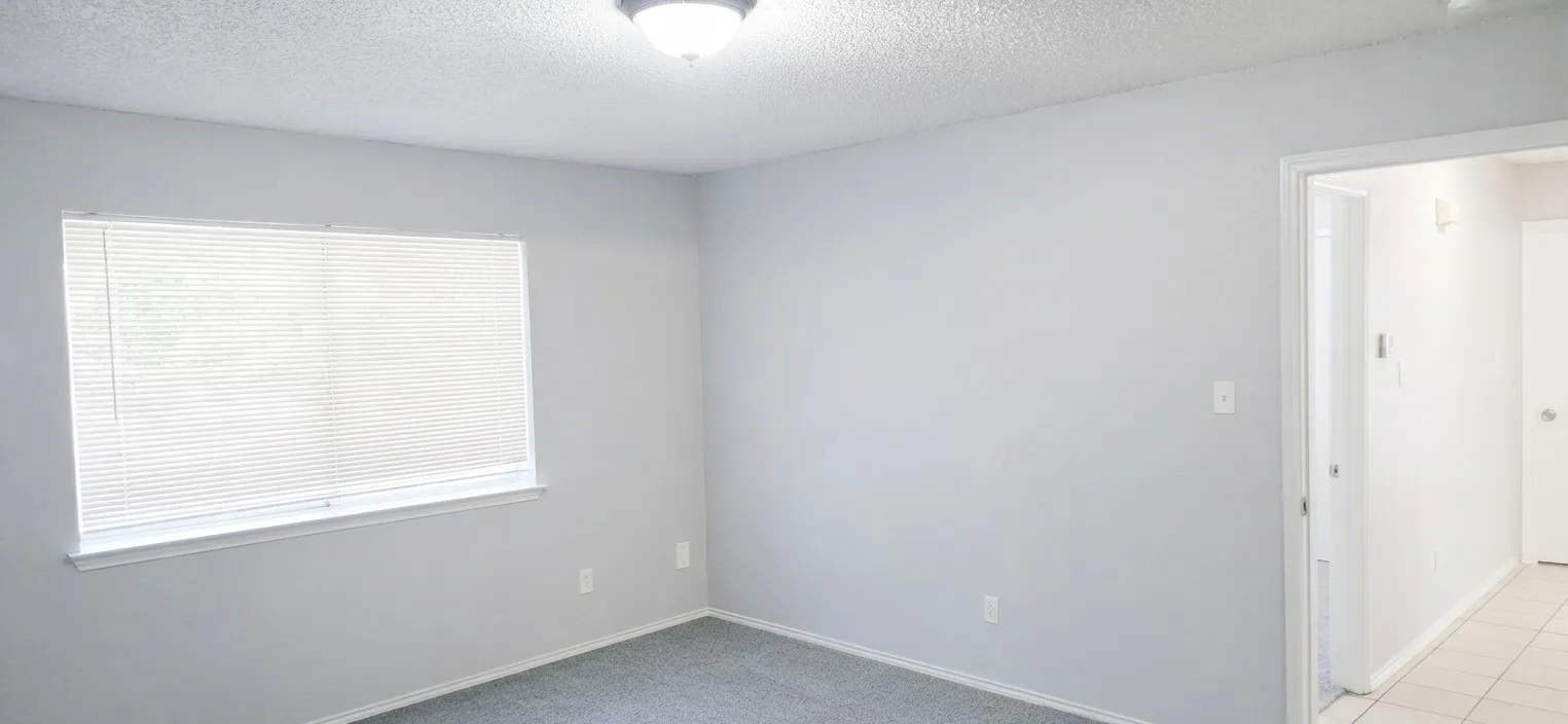 Neutral-toned interior with light grey walls, grey carpet flooring, and a flush mount ceiling light fixture