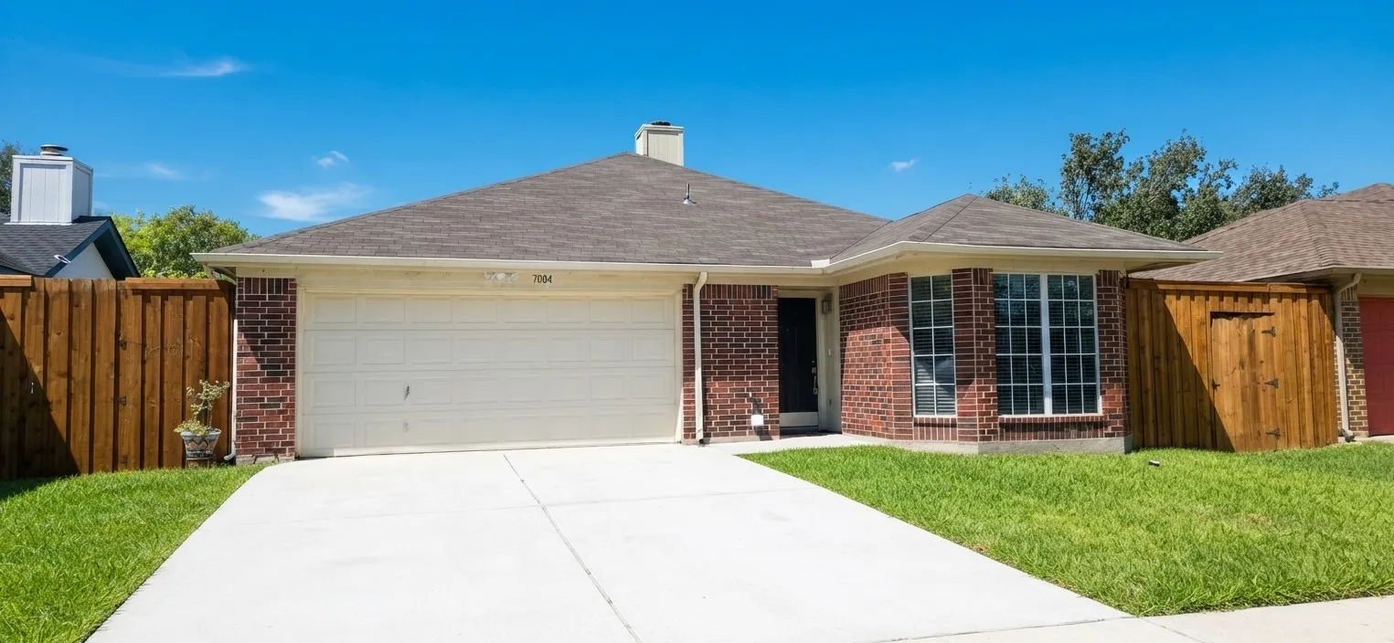 Brick exterior with a gabled roof and attached two-car garage