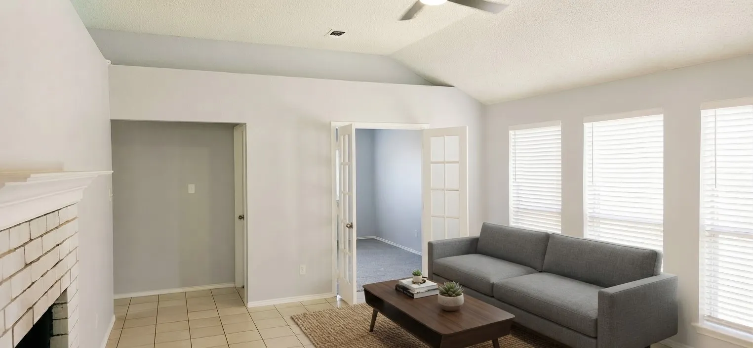 Vaulted ceiling with a ceiling fan, white brick fireplace with mantel, tiled flooring, and French doors
