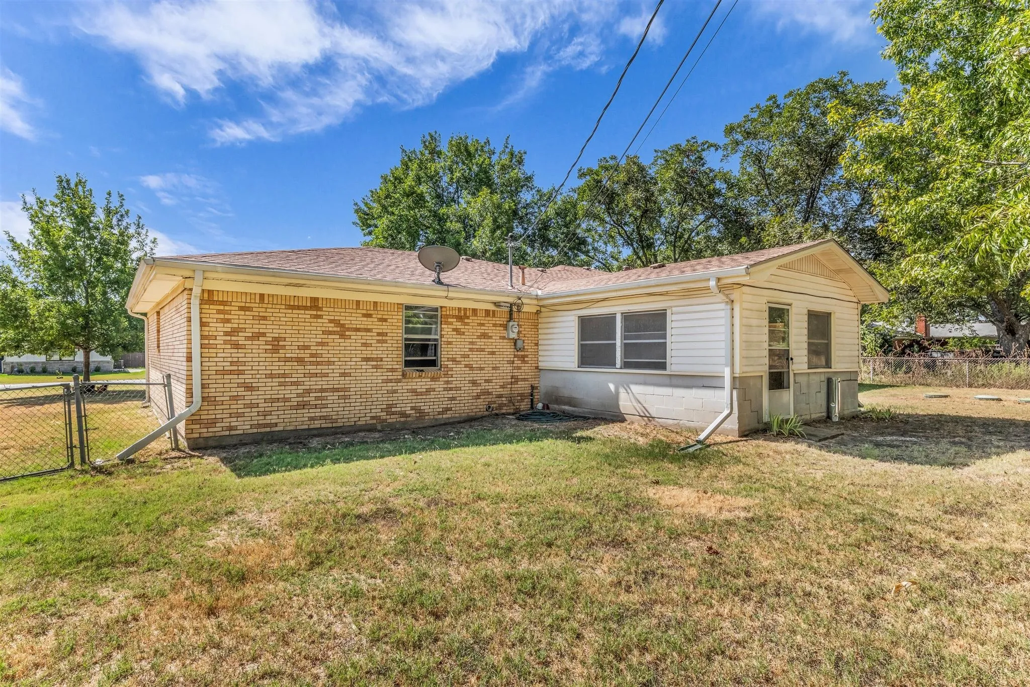 Brick exterior with a gabled roof and vinyl siding accents