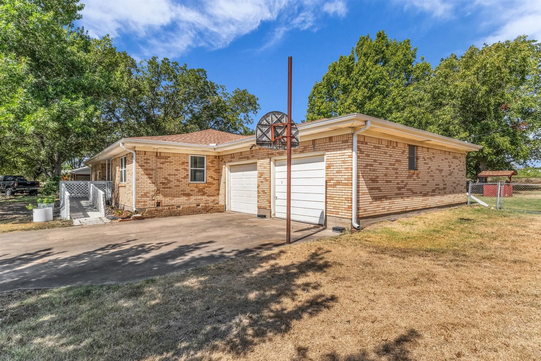 Brick exterior with two garage doors and an attached ramp entry