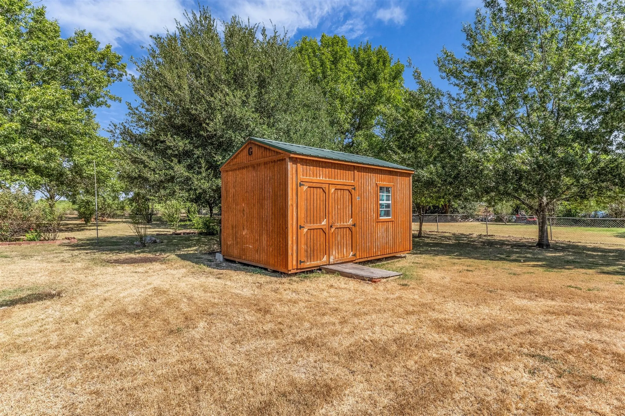 Wood-sided storage shed with a gabled roof and integrated window