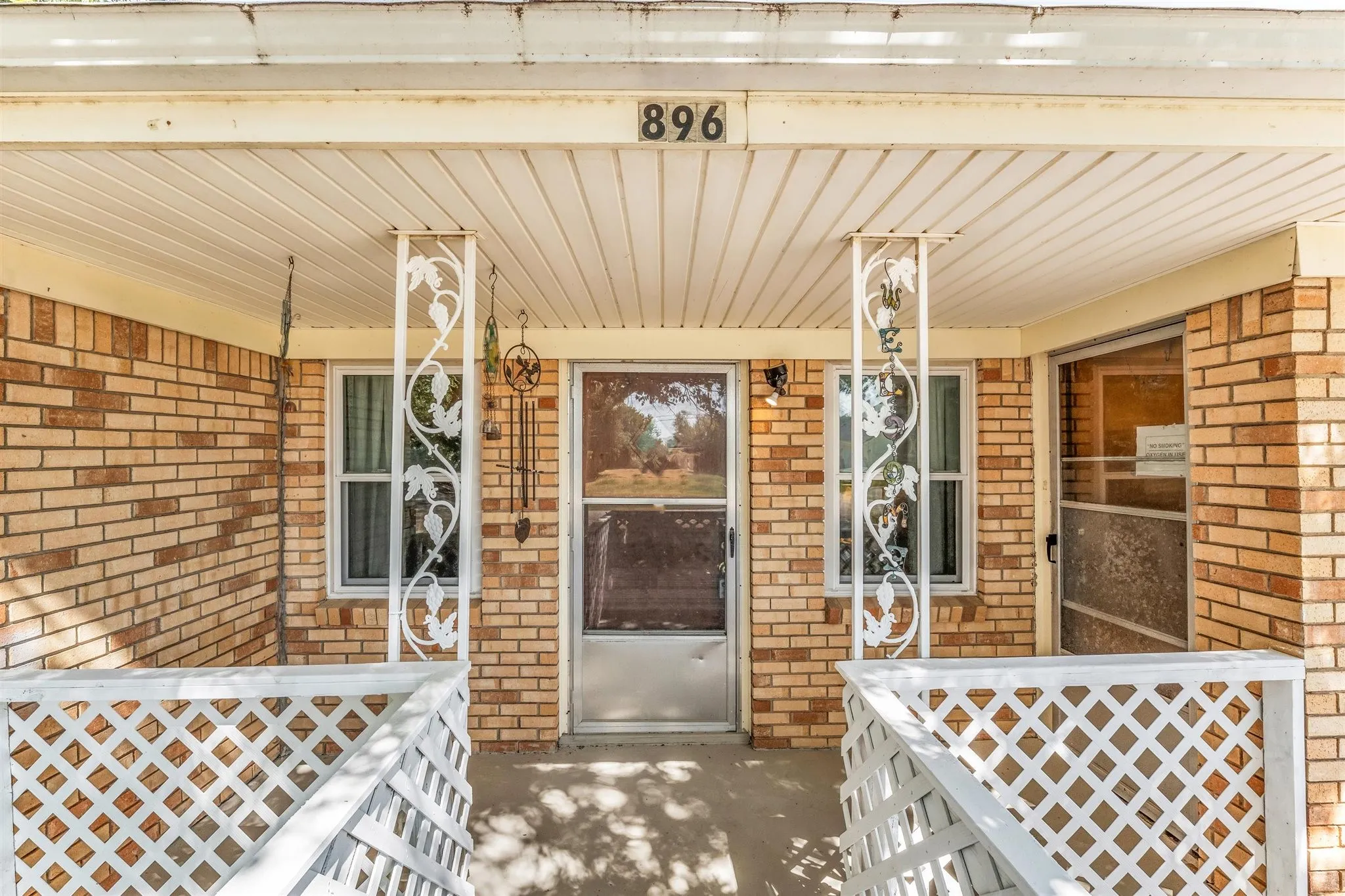Brick exterior with a covered entry and decorative metal columns