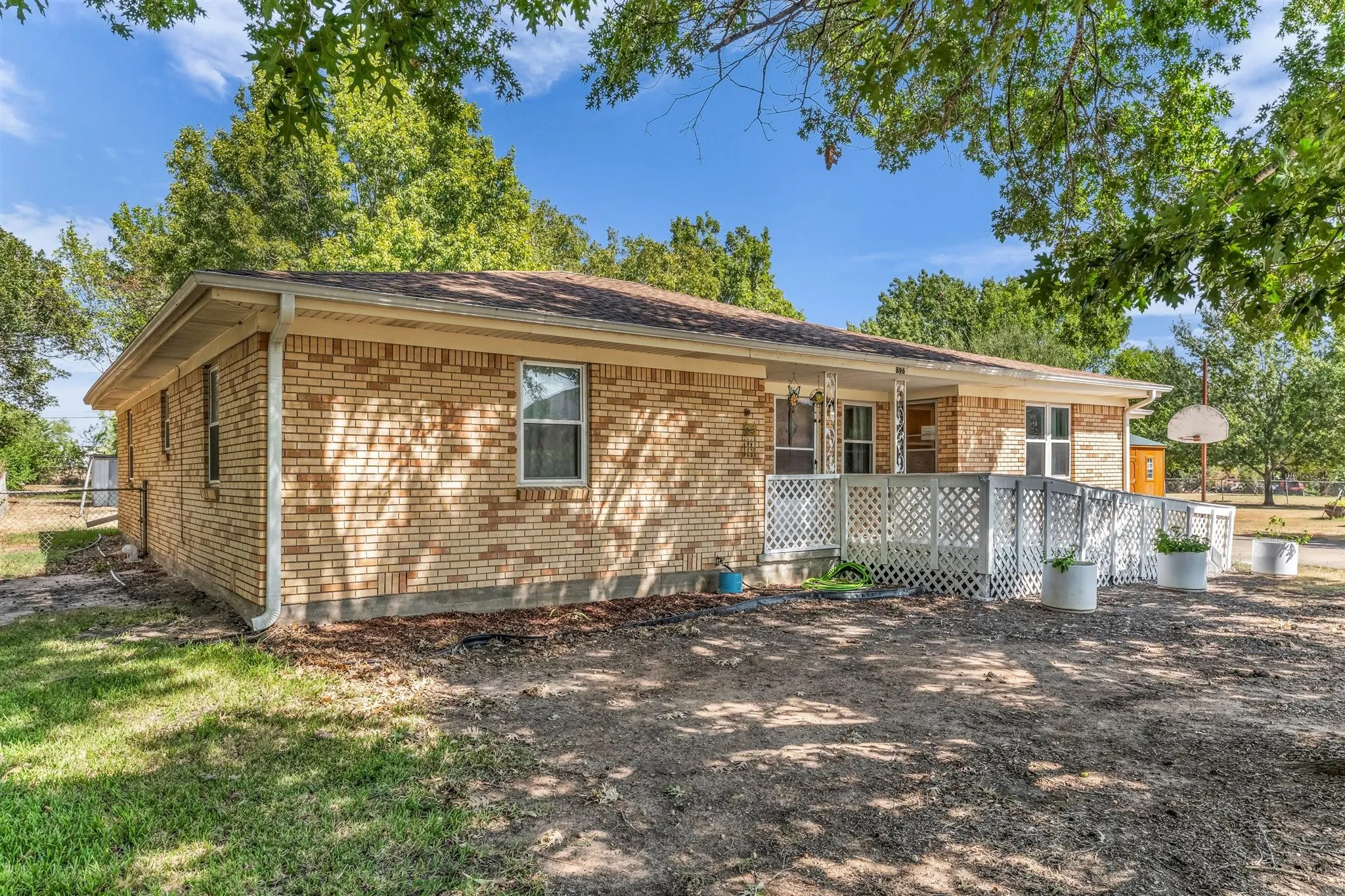 Brick exterior, covered porch, white lattice railing, and a ramp entry