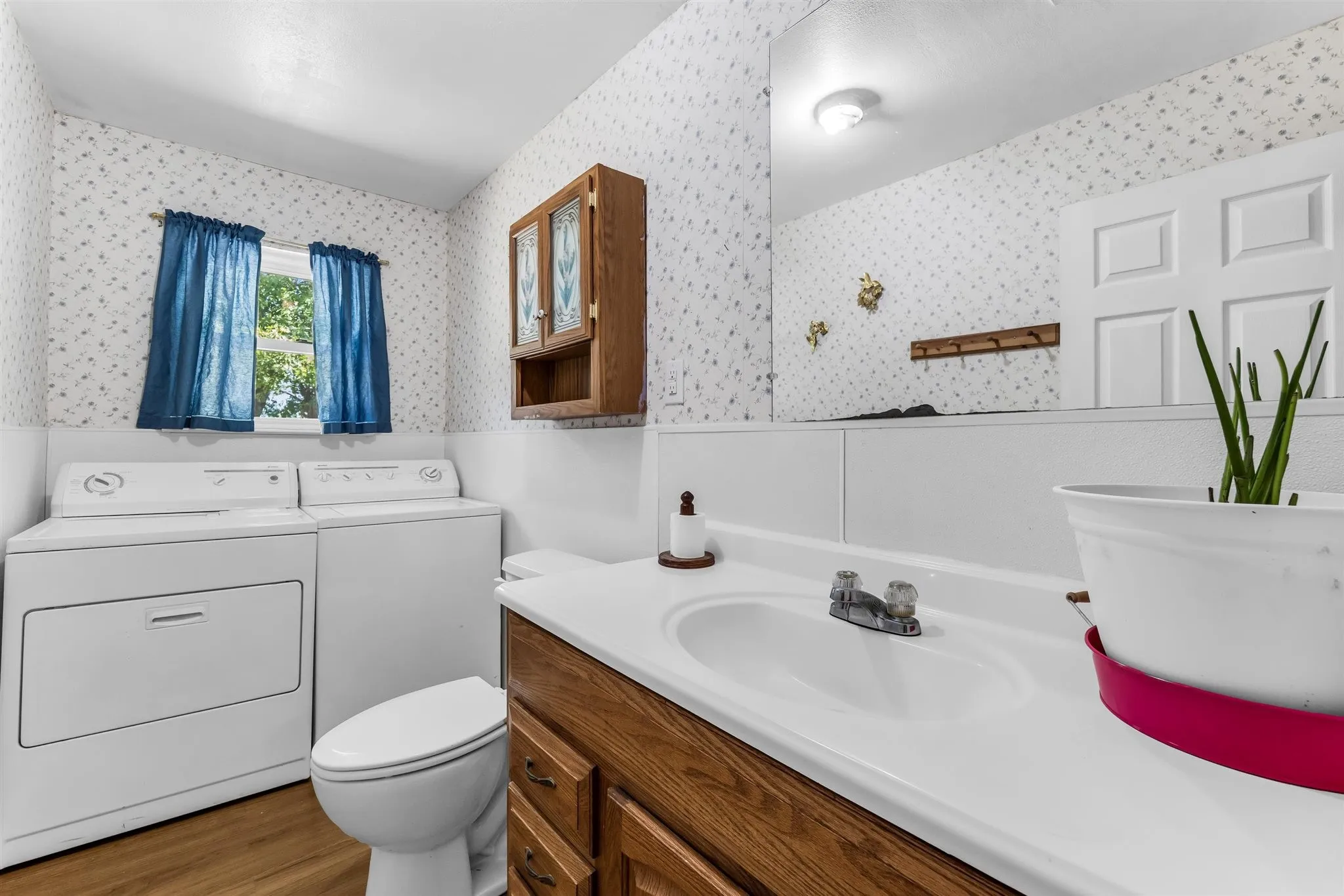 Wood-finish flooring with a vanity featuring a built-in sink and wood cabinetry