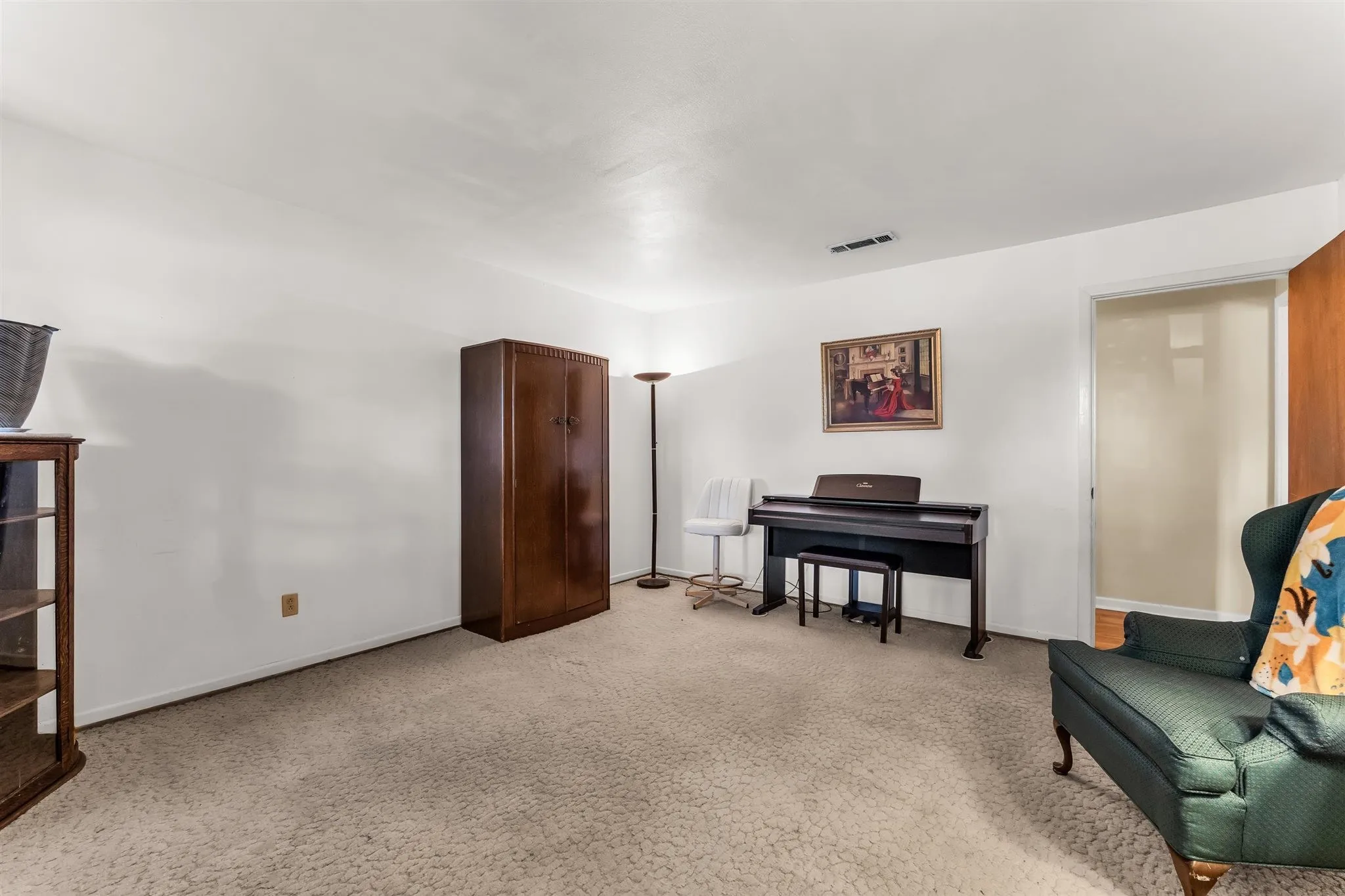 White walls with textured carpeting, featuring a doorway with wood-finish trim