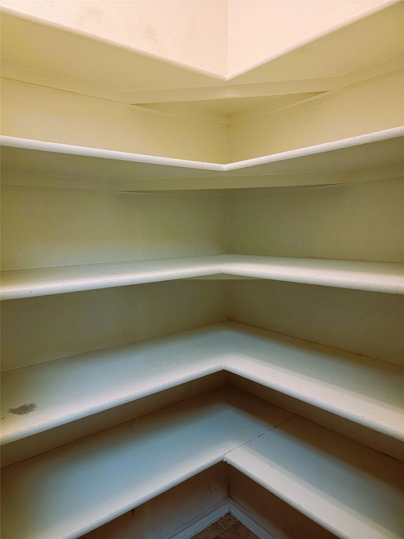Built-in shelving with multiple levels, corner design, and light-colored finish