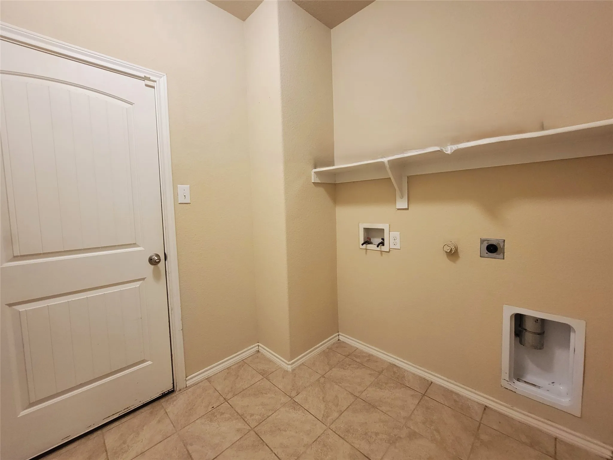 Utility area with tiled flooring and wall-mounted shelving