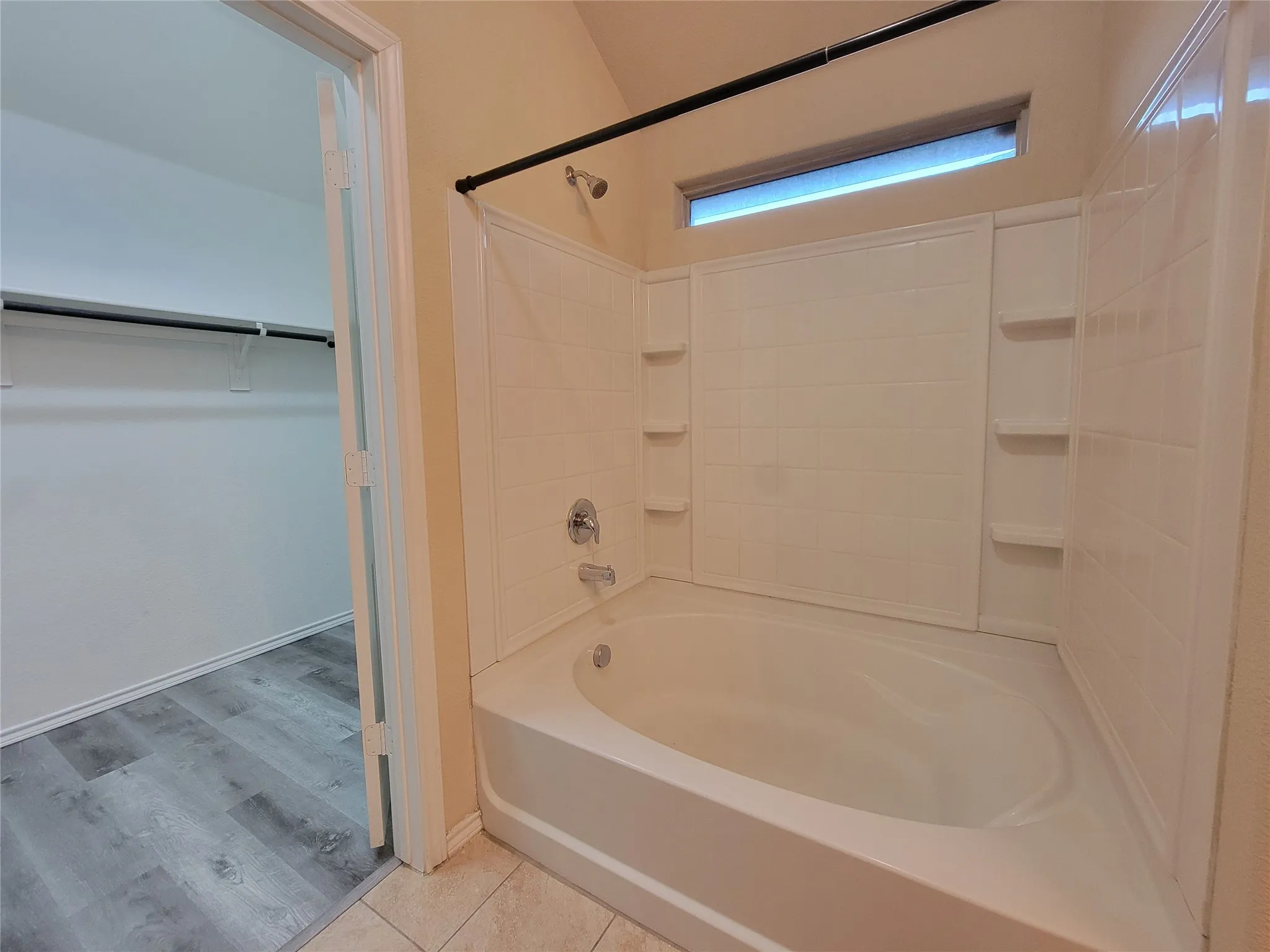 Walk-in closet with wood-finish flooring
