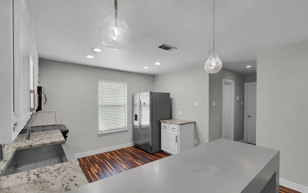 Kitchen featuring a center island, recessed lighting, wood-finish flooring, and pendant lighting