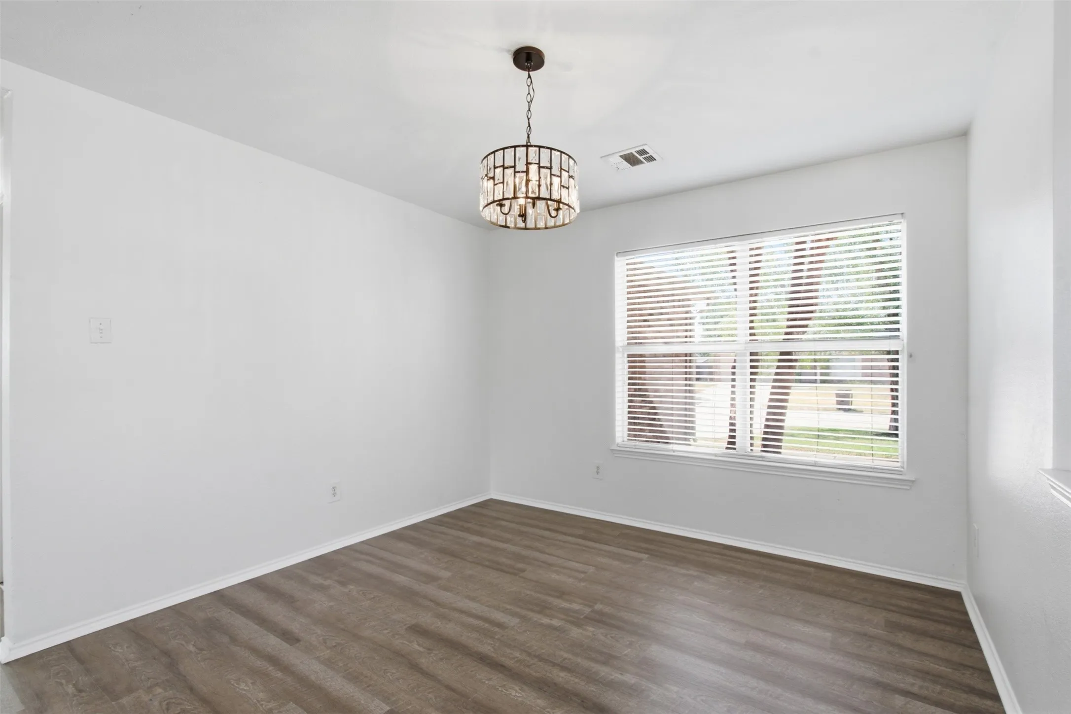 Large dining area featuring elegant decorative lighting, offering versatile utility as a spacious secondary living or entertainment room.