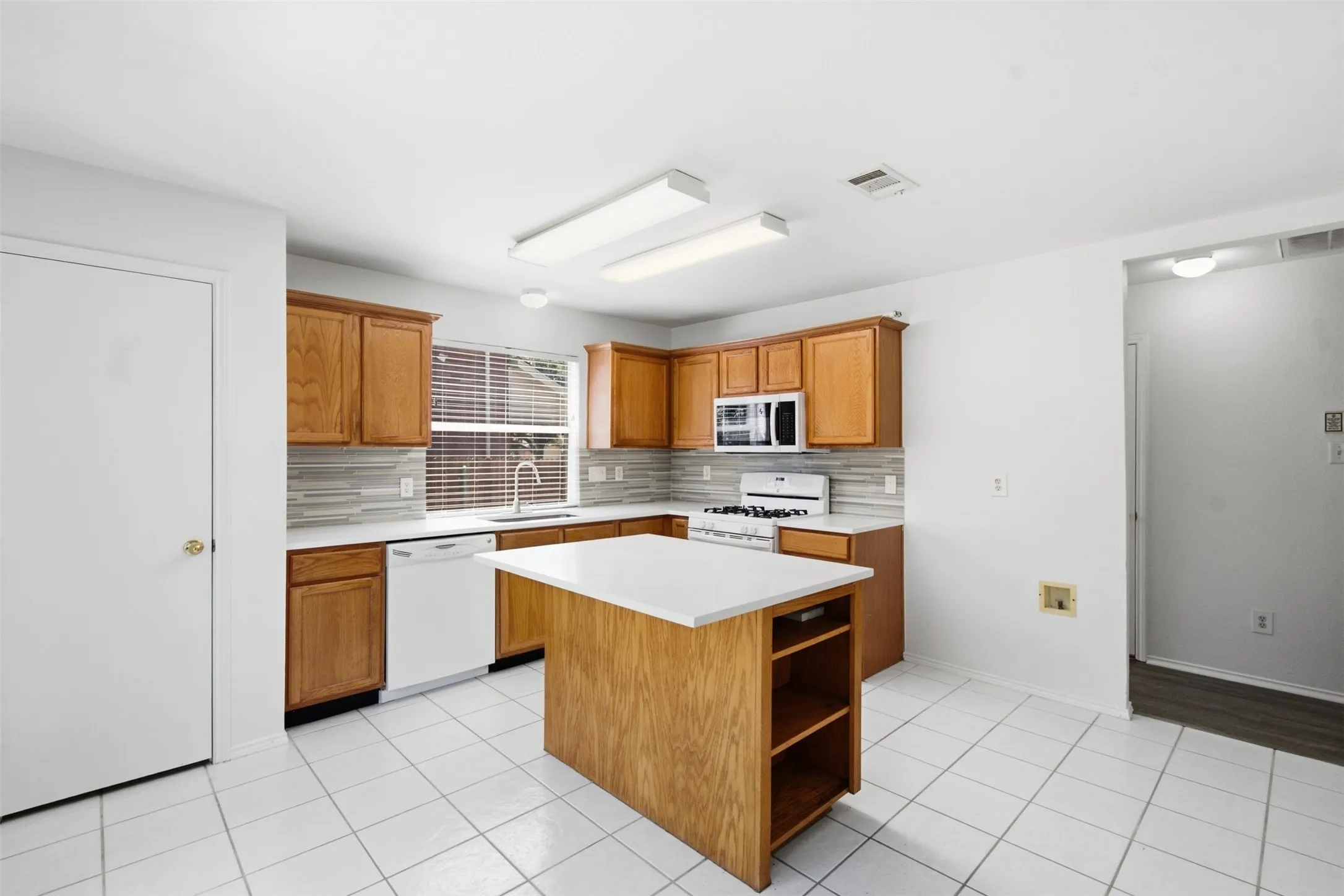 This stunning, spacious kitchen features upgraded finishes, including beautifully upgraded quartz countertops, a modern designer backsplash, premium cabinetry, and ample counter space that is perfect for both daily meal preparation and hosting elegant gatherings.