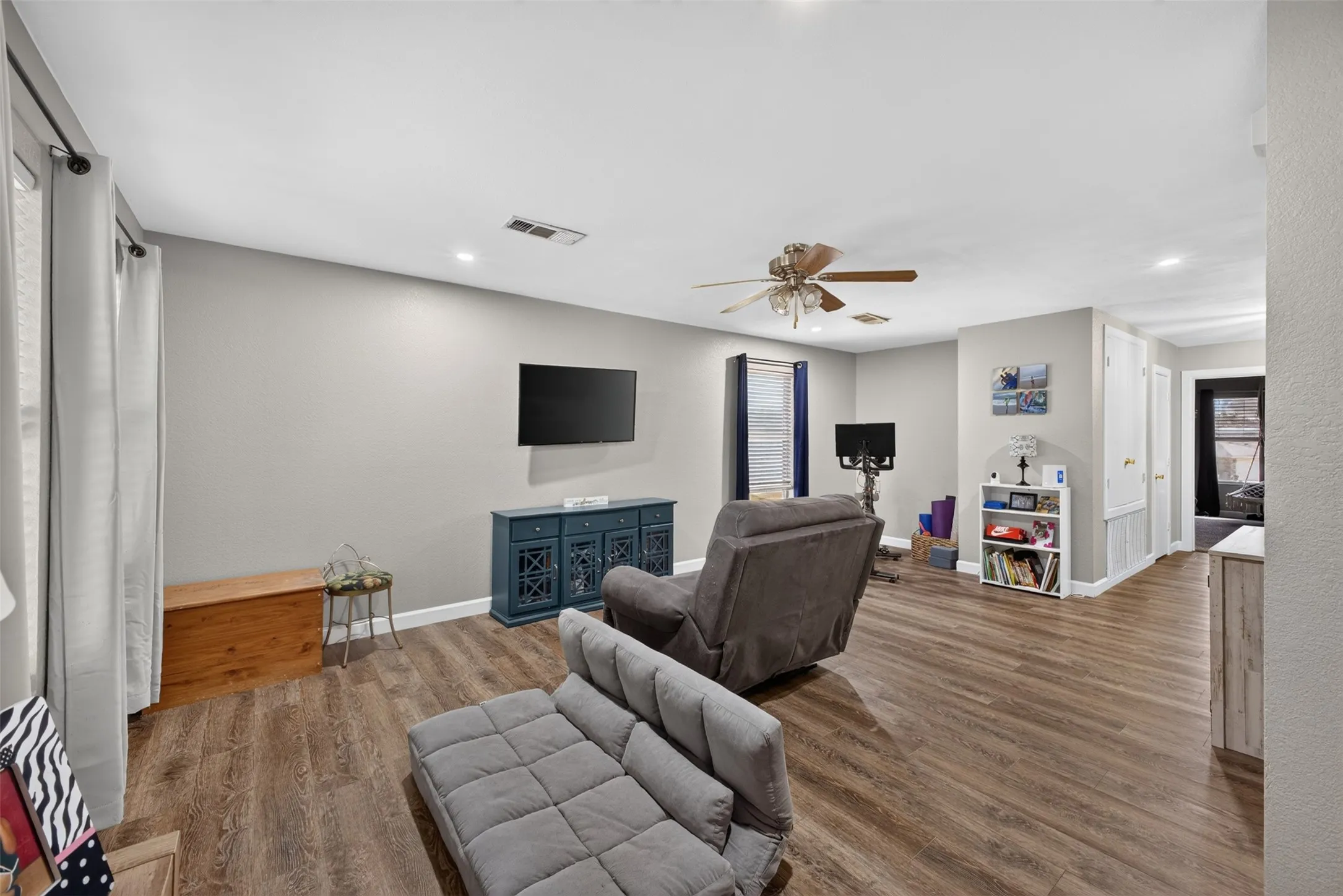 Wood-finish flooring throughout, recessed lighting, and a ceiling fan with integrated lighting