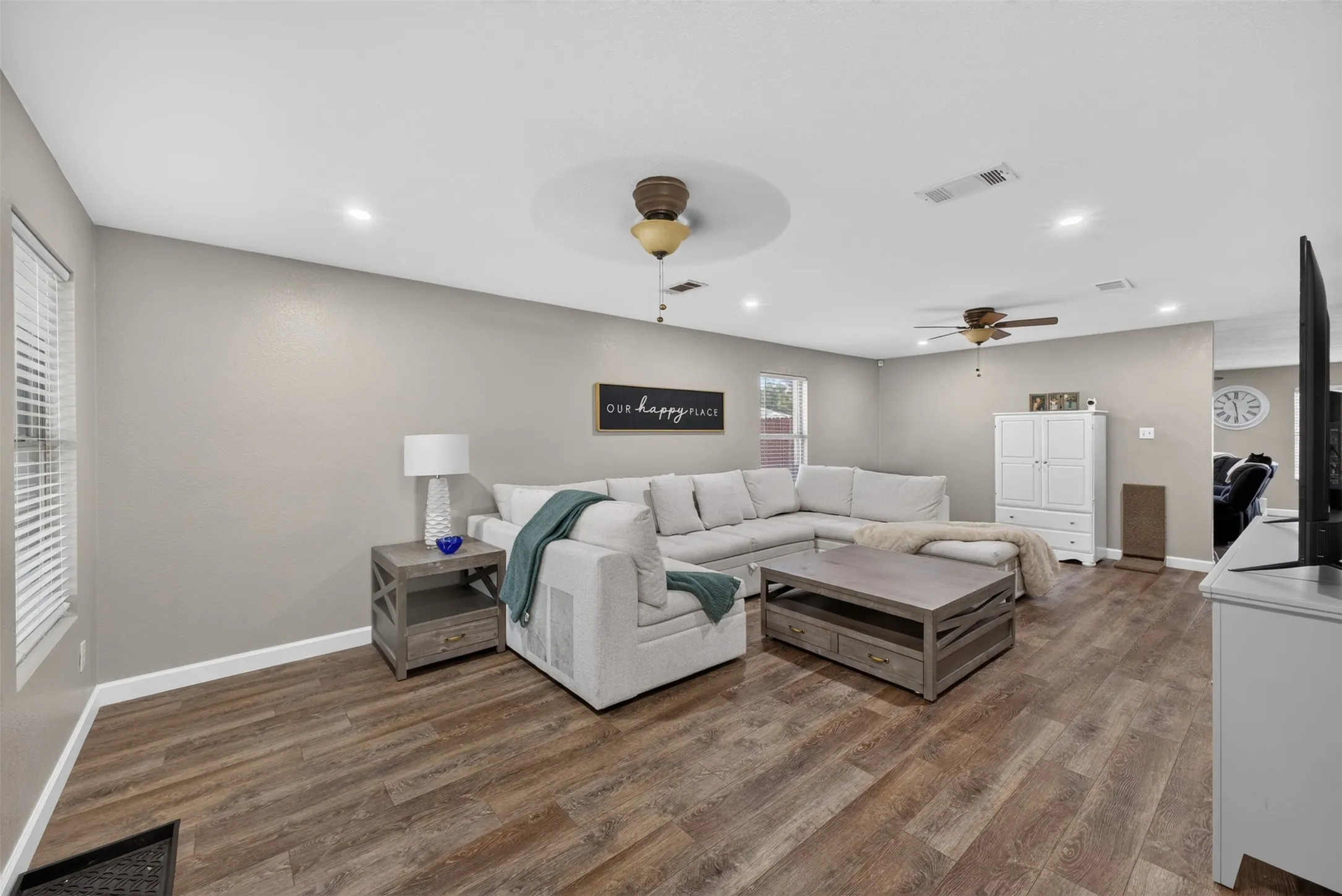 Wood-finish flooring, recessed lighting, ceiling fans, and neutral wall tones