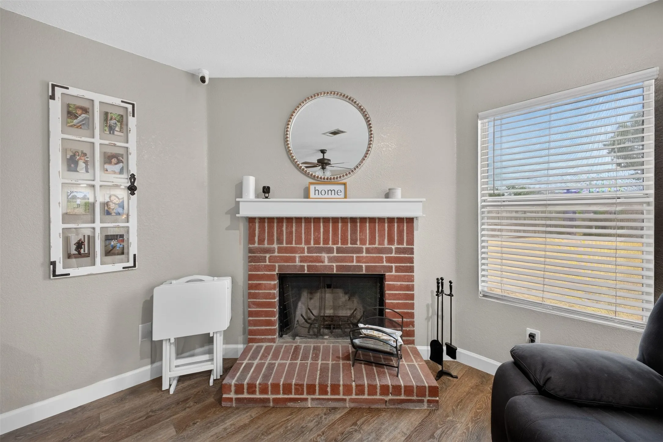Charming living room anchored by a classic red brick fireplace with decorative hearth and mantel styling