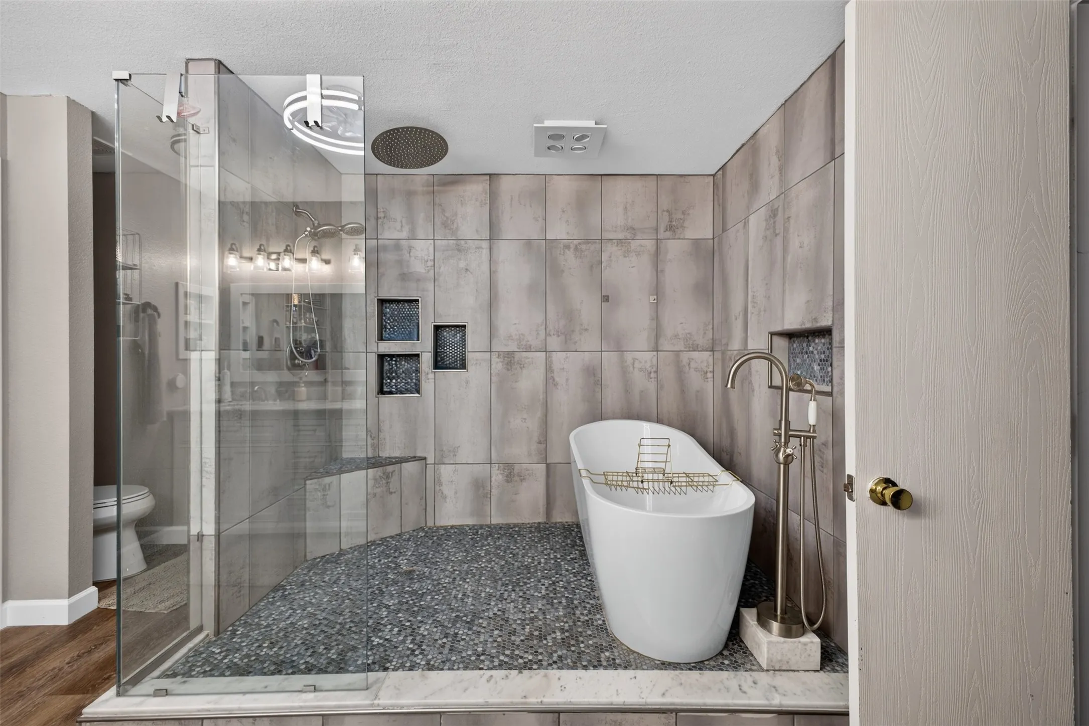 Walk-in shower with glass enclosure, built-in bench, and rain shower head