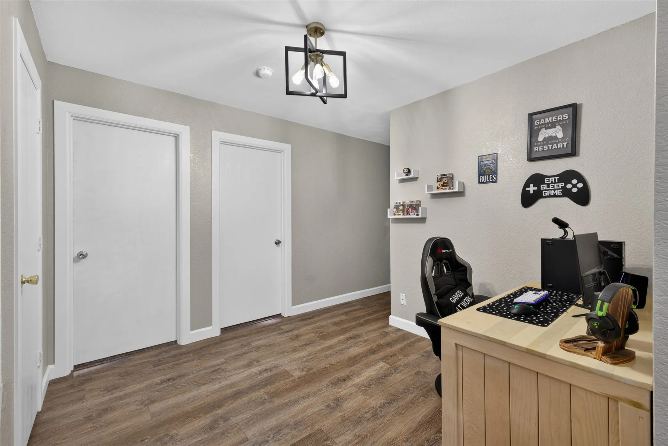 Wood-finish flooring, neutral wall tones, white trim, and a contemporary ceiling fixture