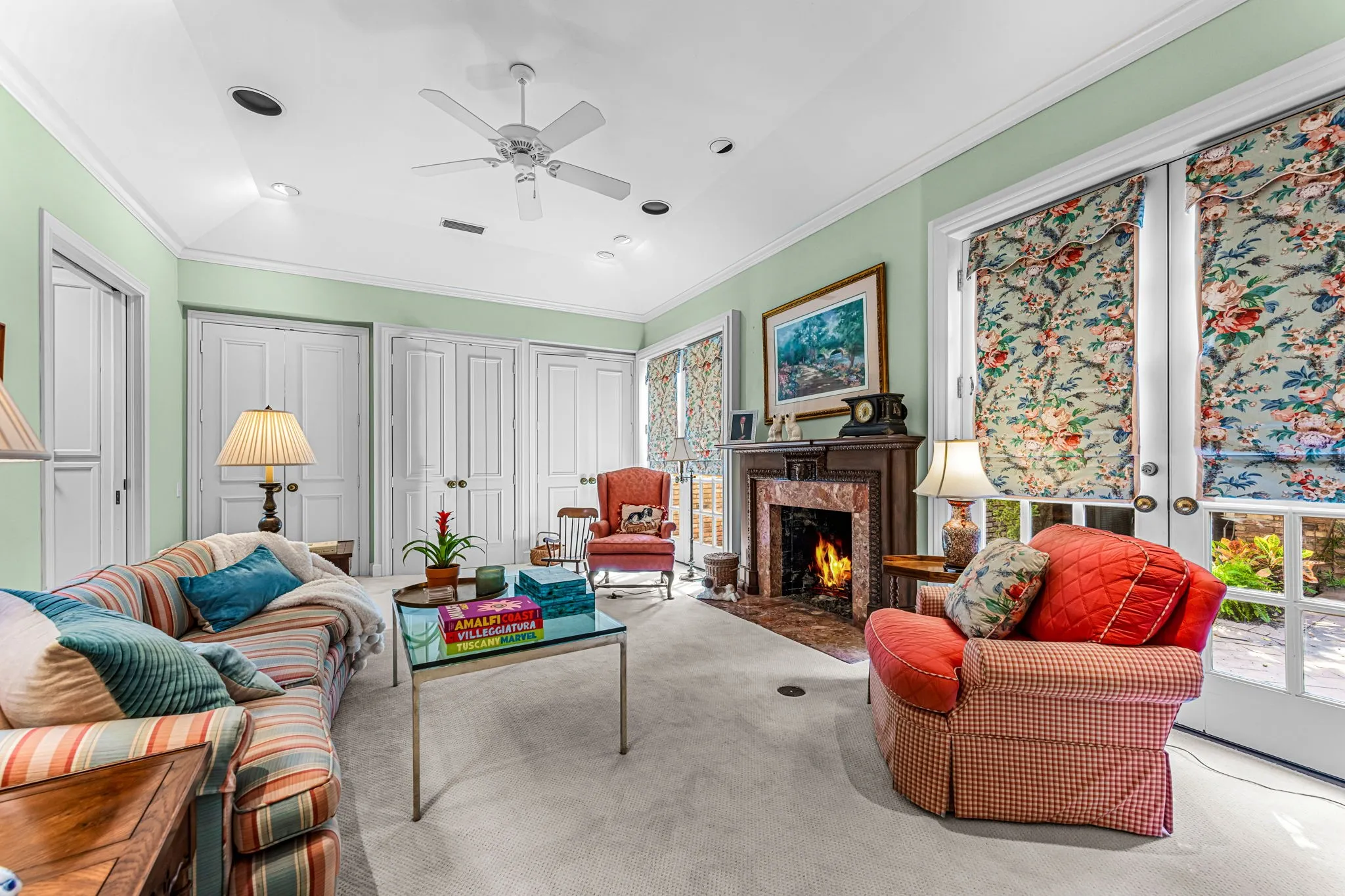 Recessed lighting, ceiling fan, fireplace with a marble surround, wood mantel, and multiple French doors