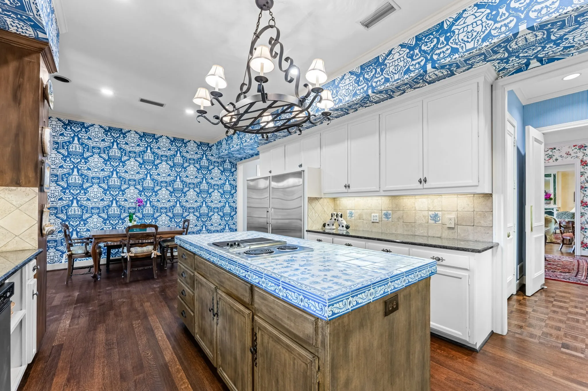 Kitchen featuring a tiled island cooktop, white cabinetry, integrated stainless steel refrigeration, and wood-finish flooring