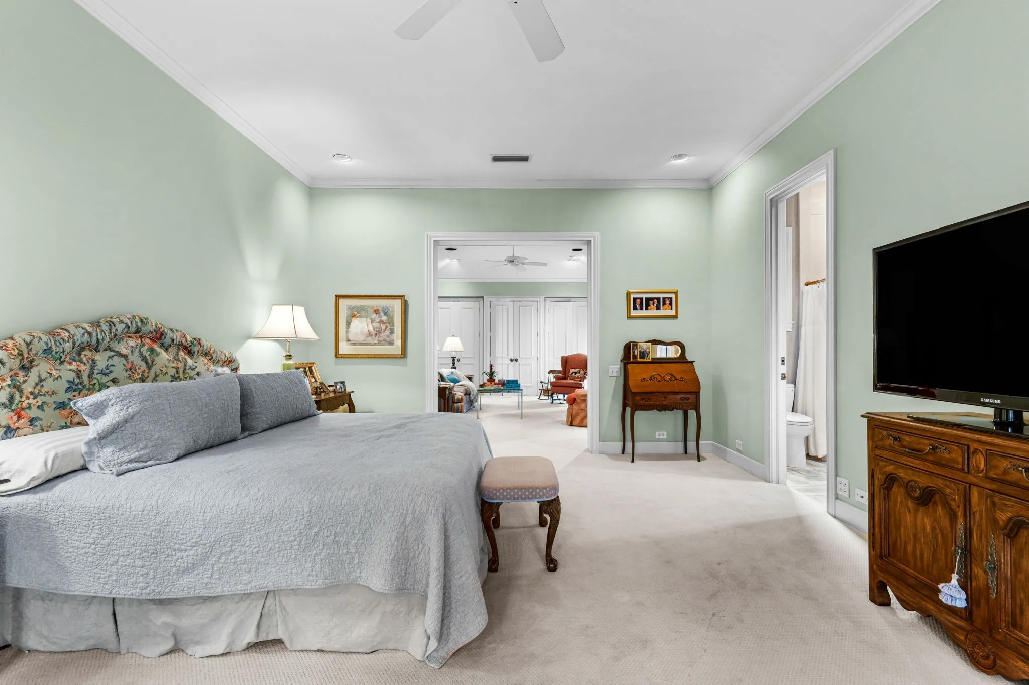 Carpeted room with light green walls, crown molding, and a ceiling fan