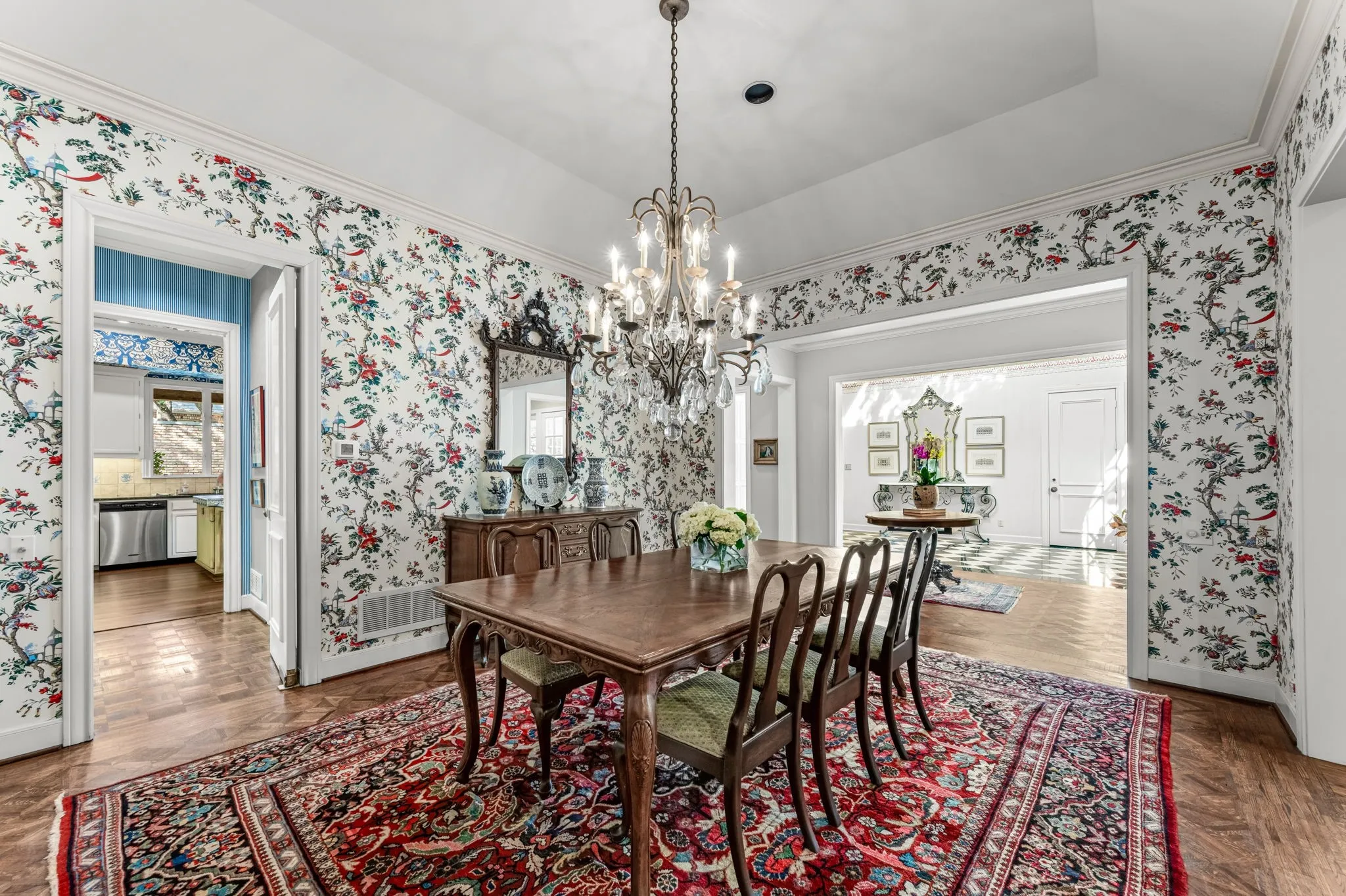Wood-finish flooring, decorative wallpaper, and a crystal chandelier