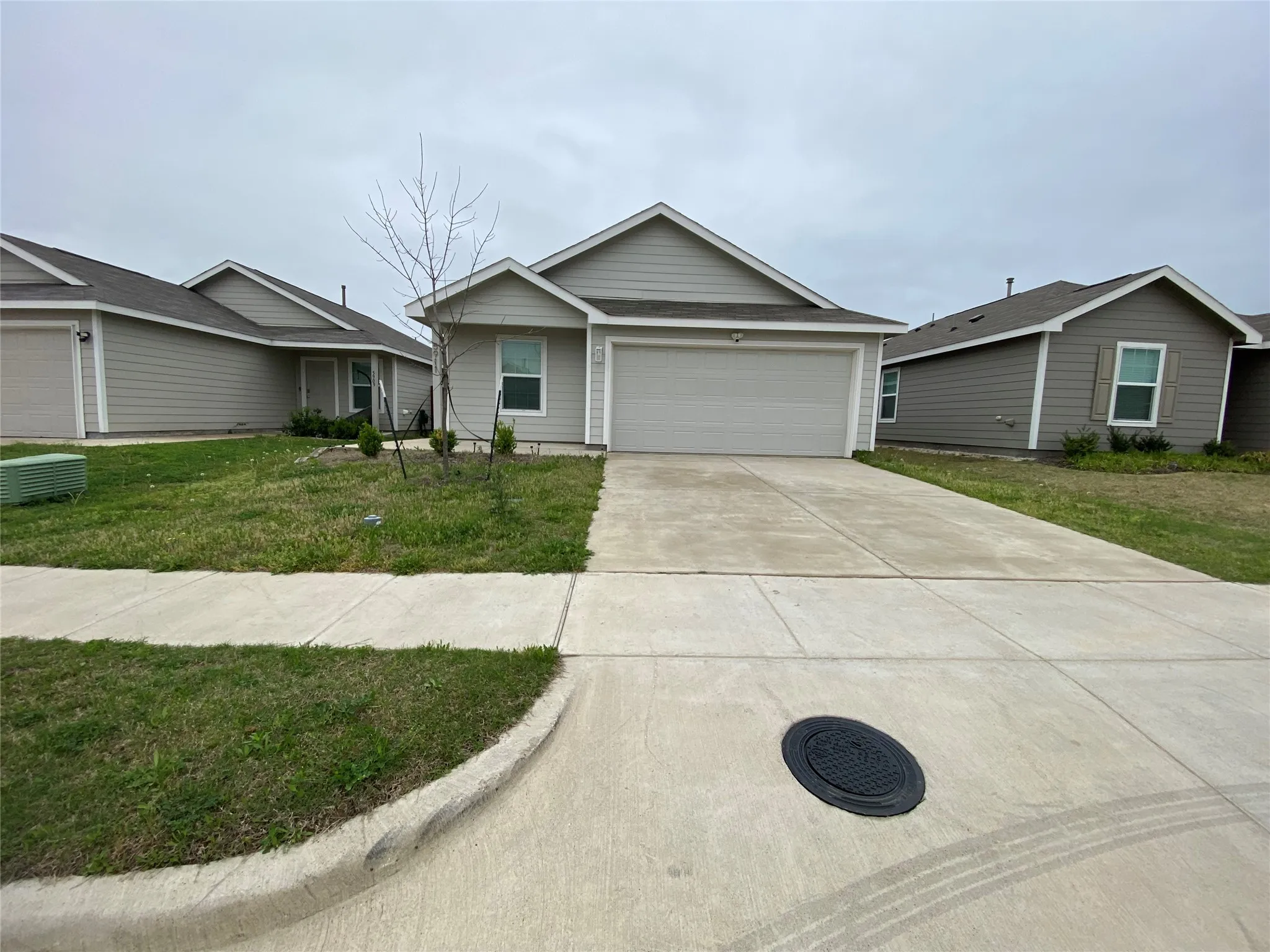 Ranch-style home featuring a front lawn, driveway, and a garage