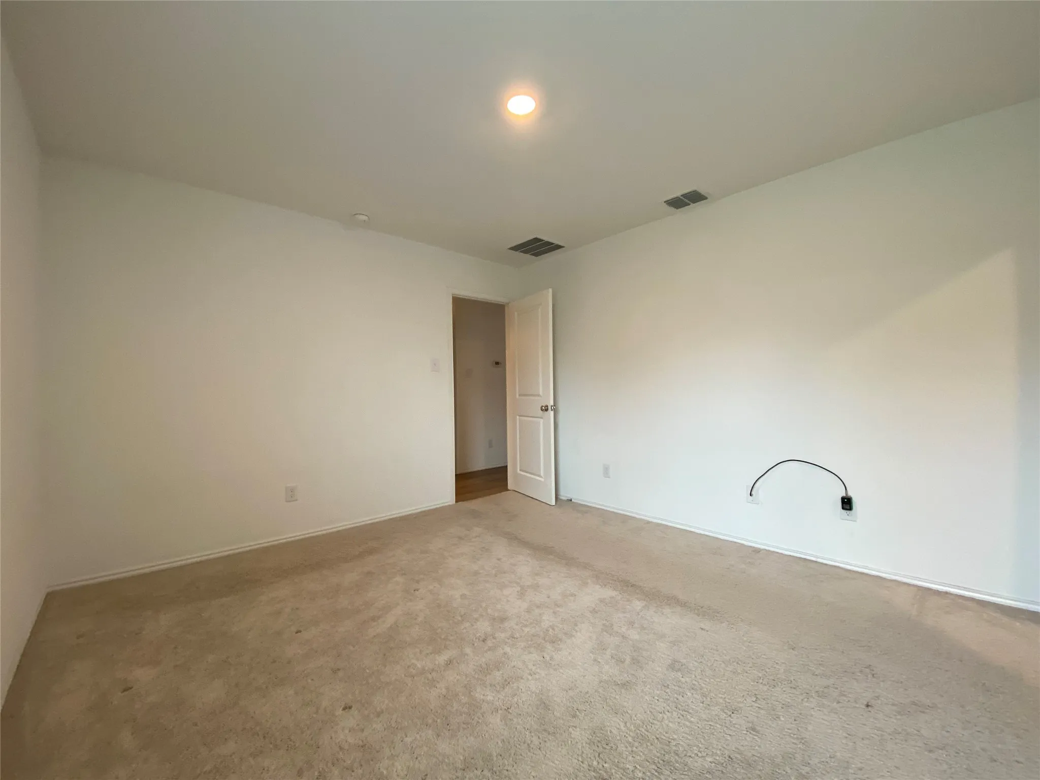 Carpeted spare room with visible vents