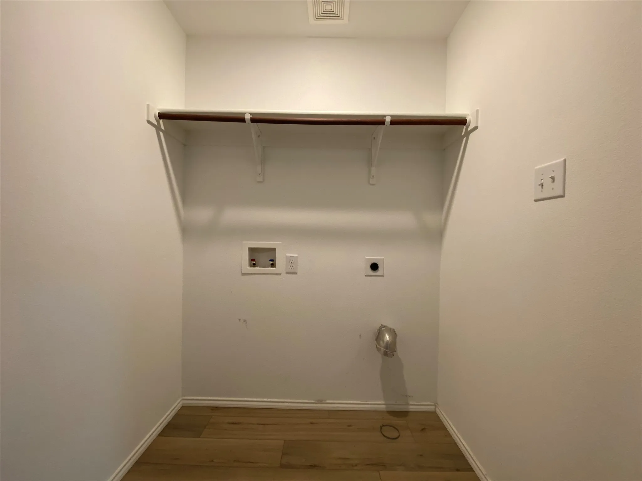 Clothes washing area with visible vents, hookup for a washing machine, wood finished floors, laundry area, and hookup for an electric dryer